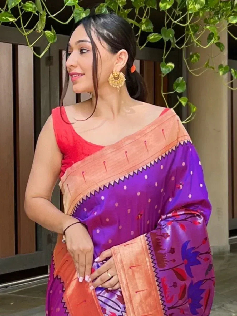 Woman in vibrant purple and orange printed saree with gold earrings, styled for ethnic occasions
