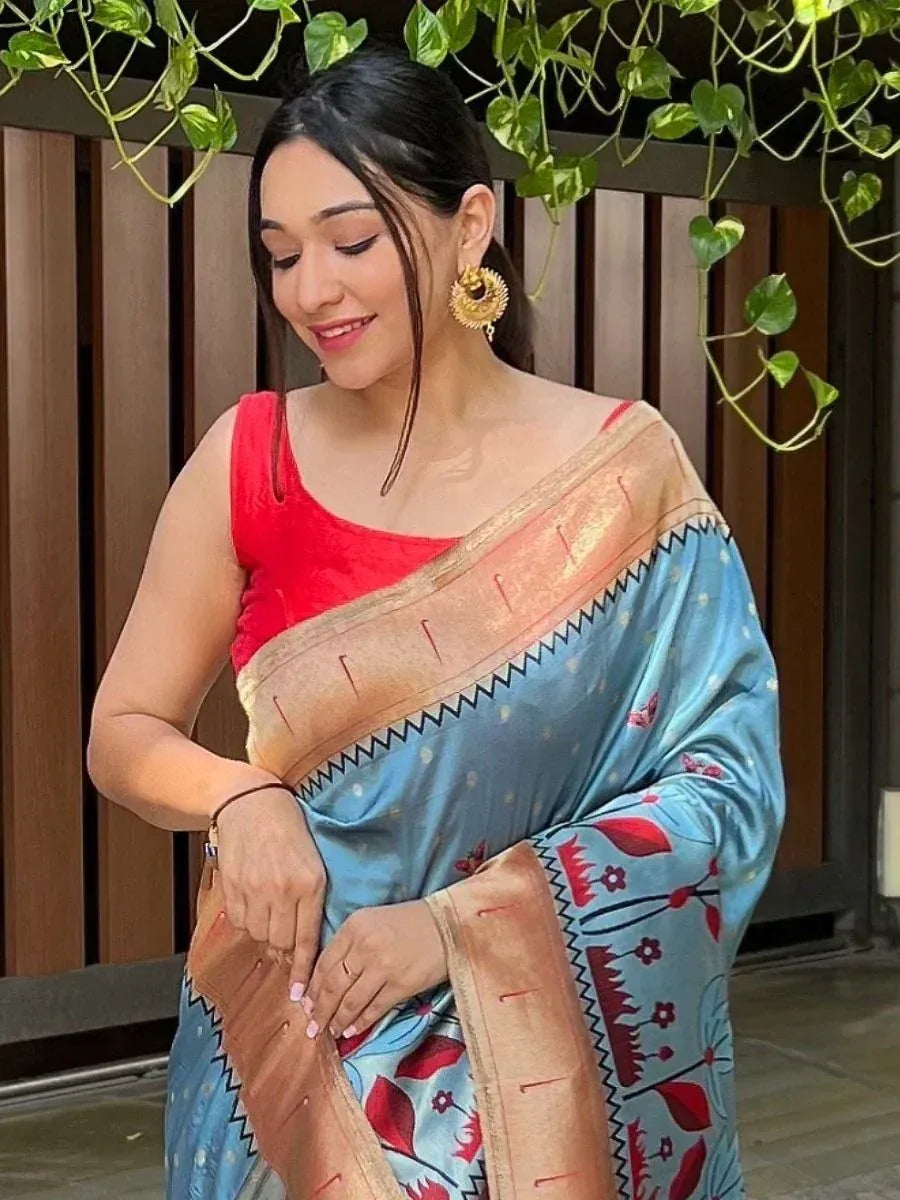 Woman in blue floral saree with red blouse and gold earrings, ethnic Indian wear