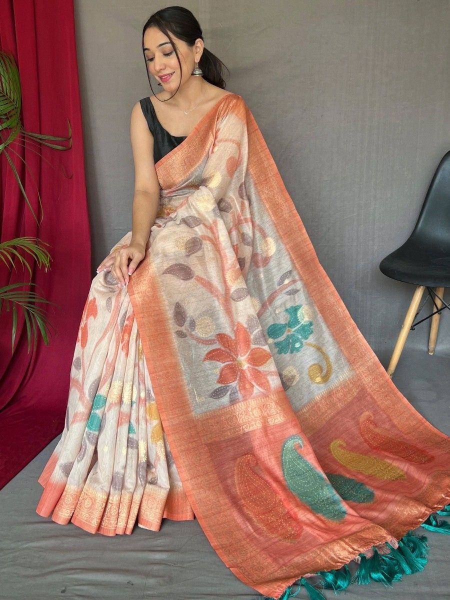 Woman wearing floral print saree with peach border and teal tassels, styled with black blouse for ethnic occasions