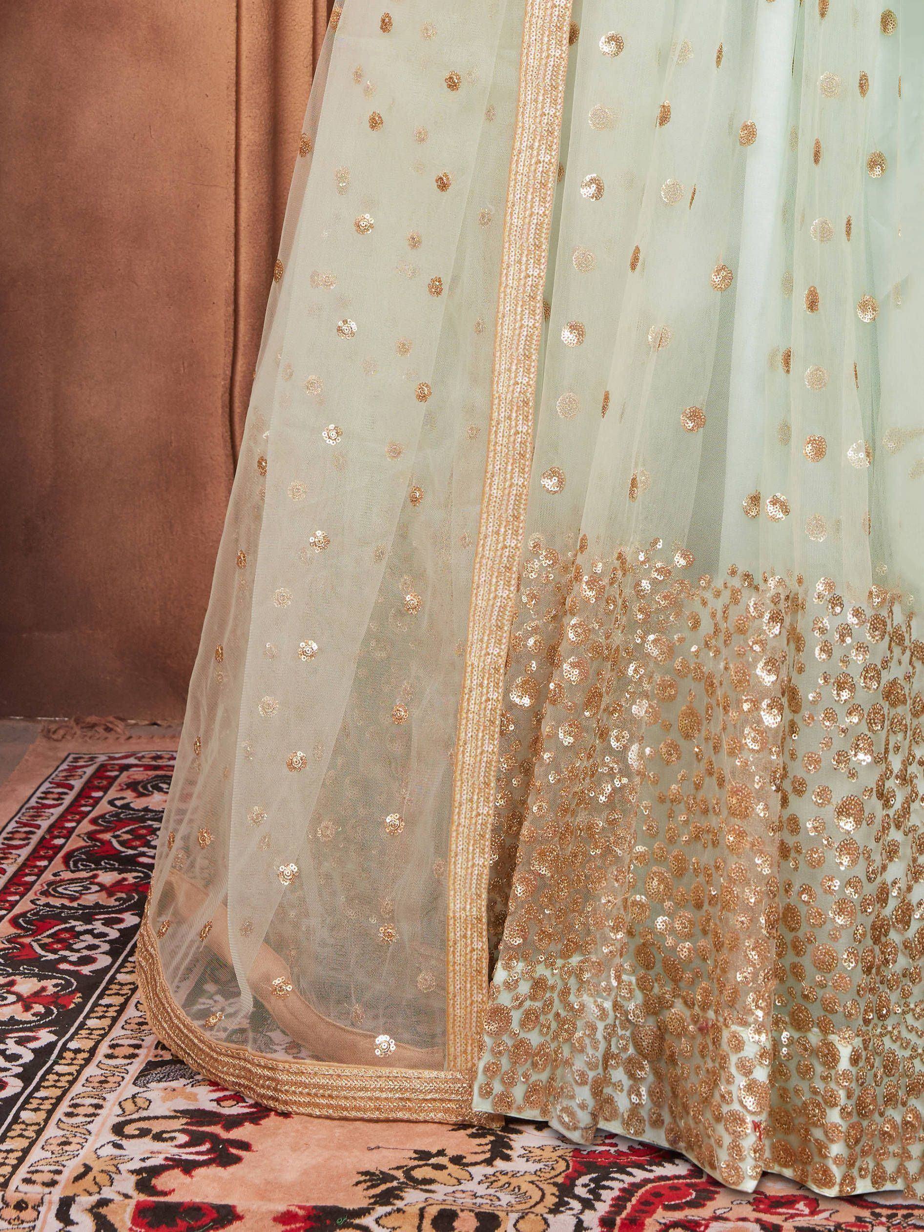 Mint green ethnic lehenga with gold sequin embroidery and sheer dupatta, perfect for Indian weddings and festive occasions.