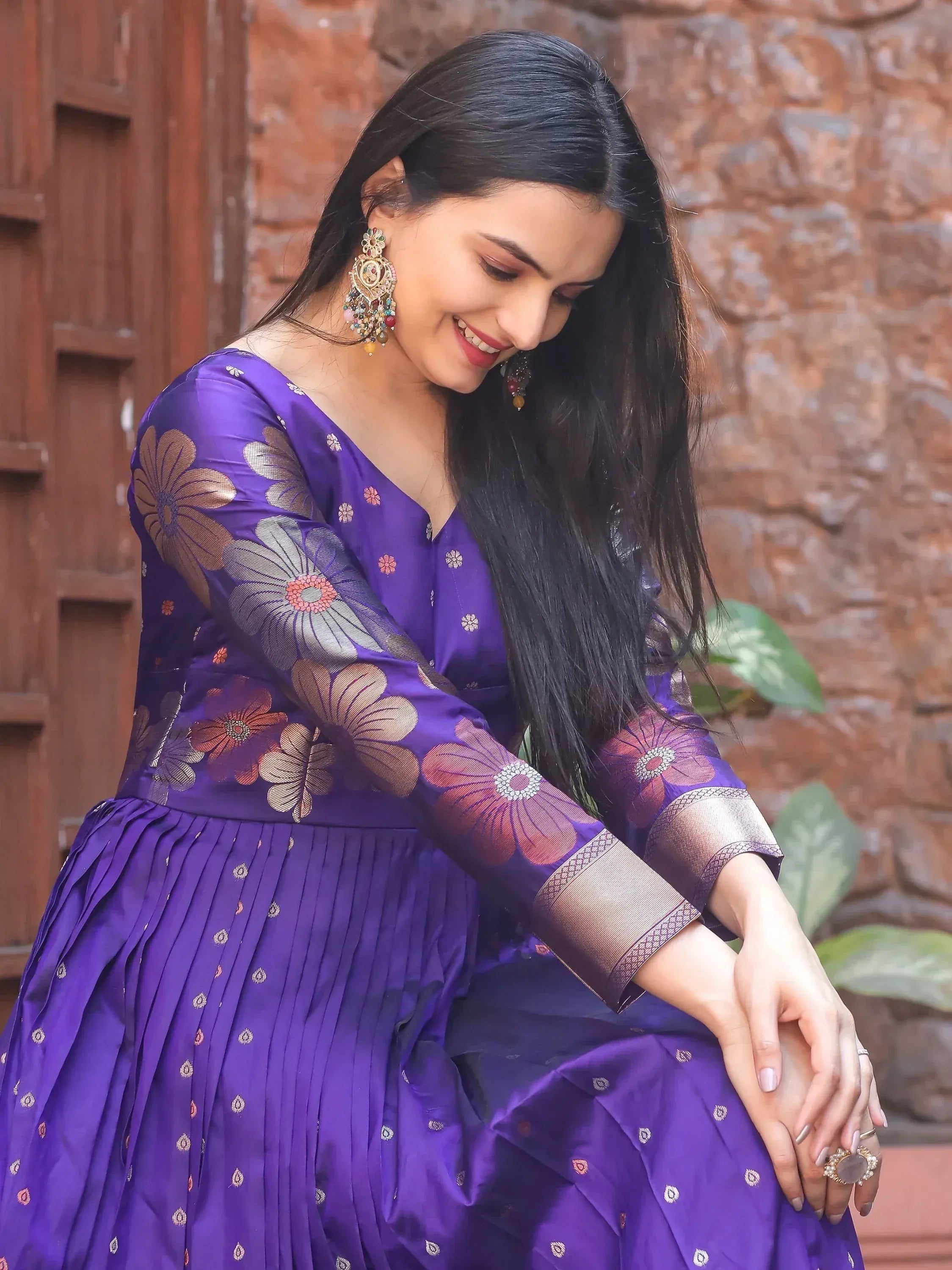 Woman in purple floral ethnic gown with gold embroidery, traditional Indian wear