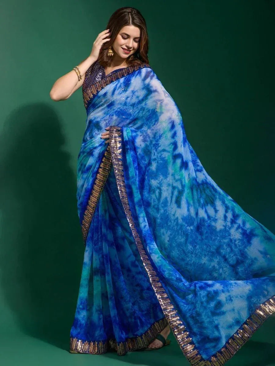 Blue tie-dye saree with gold border, styled with embellished blouse for ethnic wear