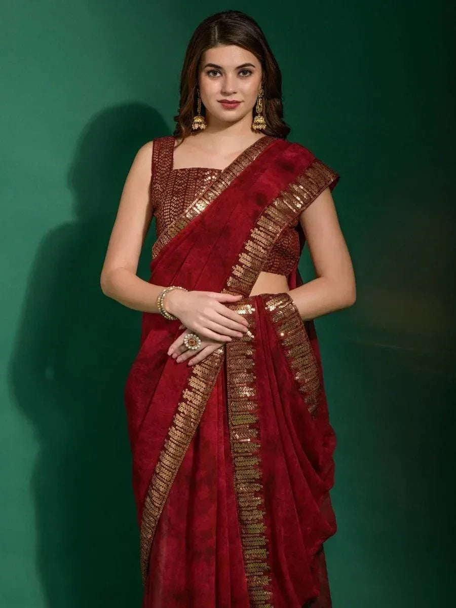 Rich maroon saree with gold embroidery, paired with matching blouse and traditional jewelry for ethnic wear.