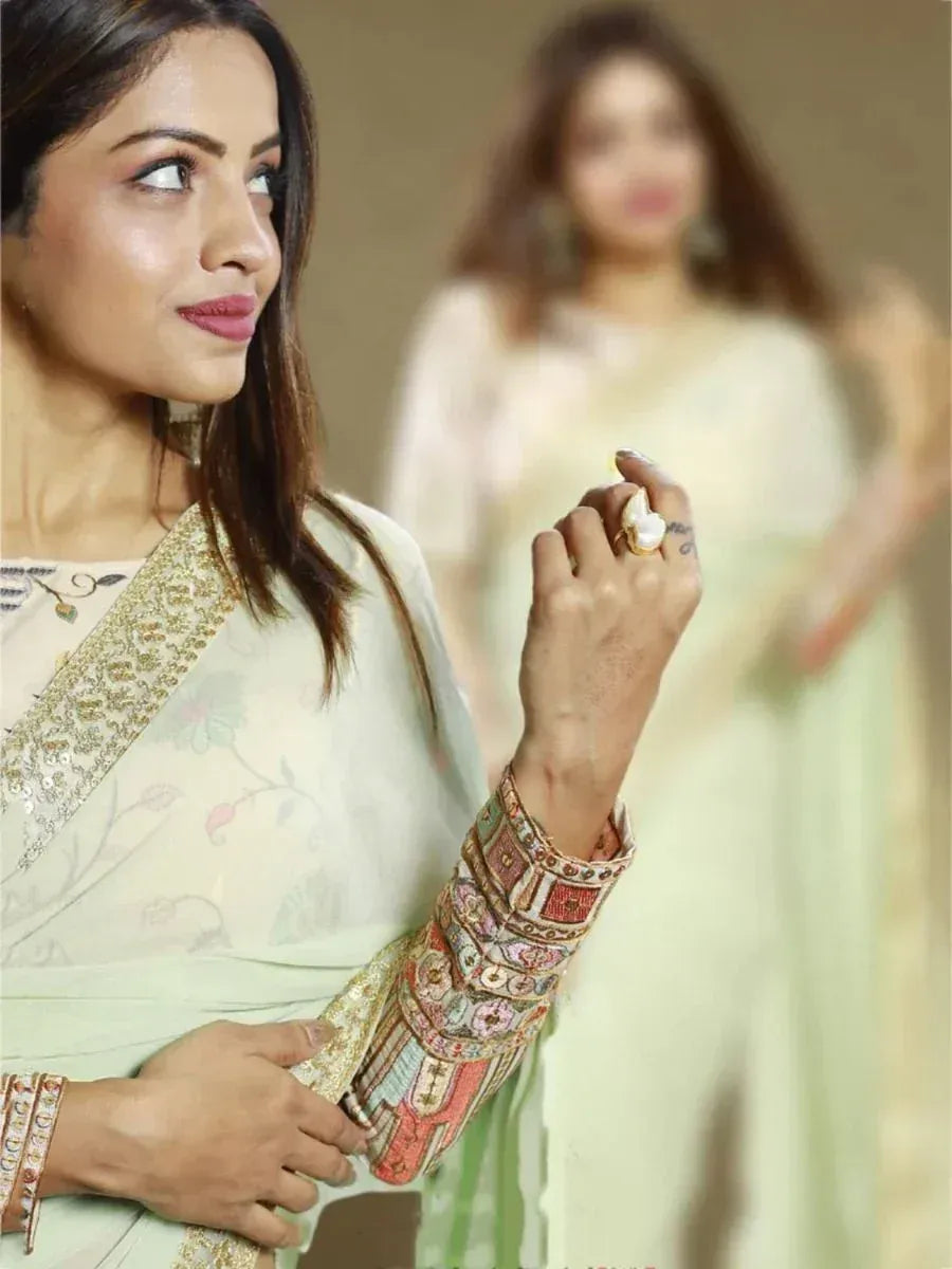 Woman in elegant Indian saree with embroidered blouse and gold border, showcasing ethnic wear style.