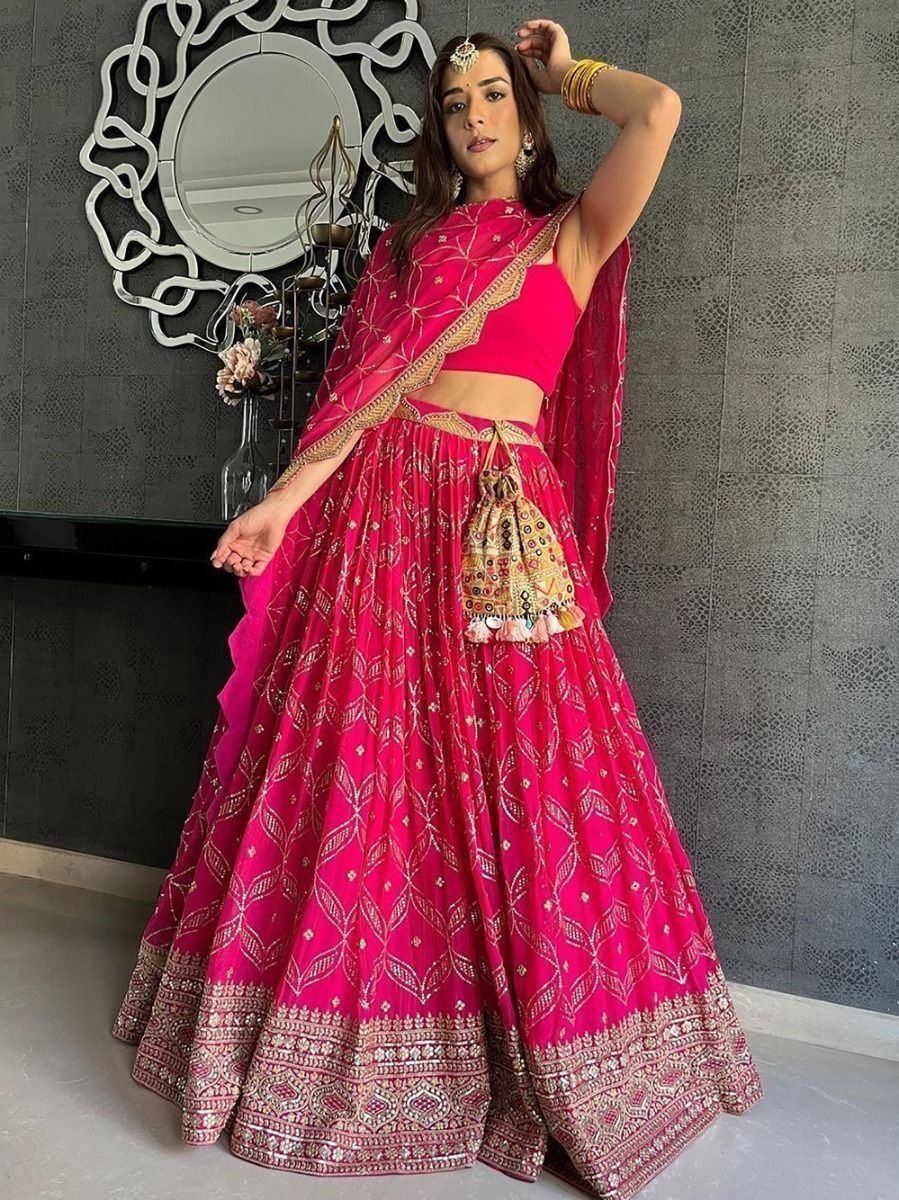 Fuchsia pink embroidered lehenga choli with gold detailing, perfect for Indian weddings and festive occasions