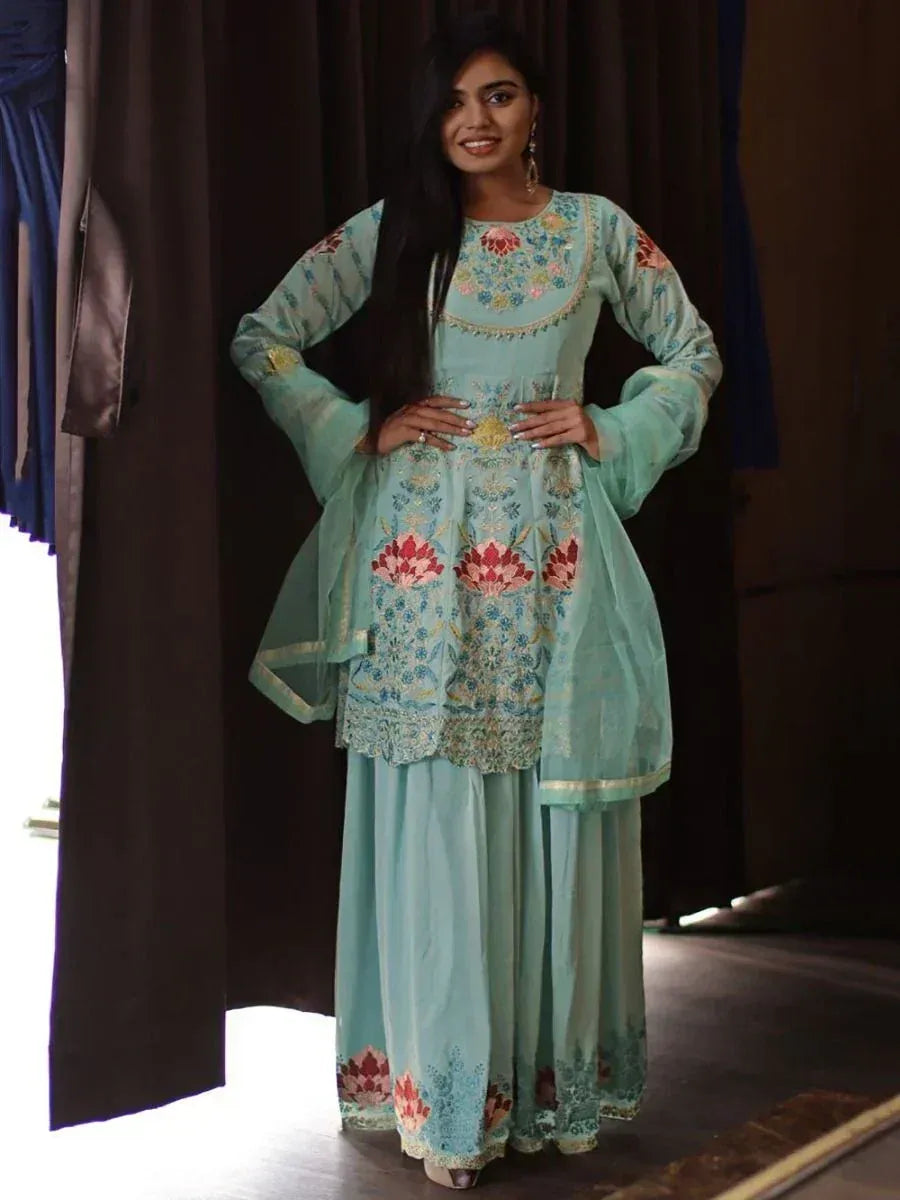 Woman wearing a light blue embroidered salwar kameez with floral patterns