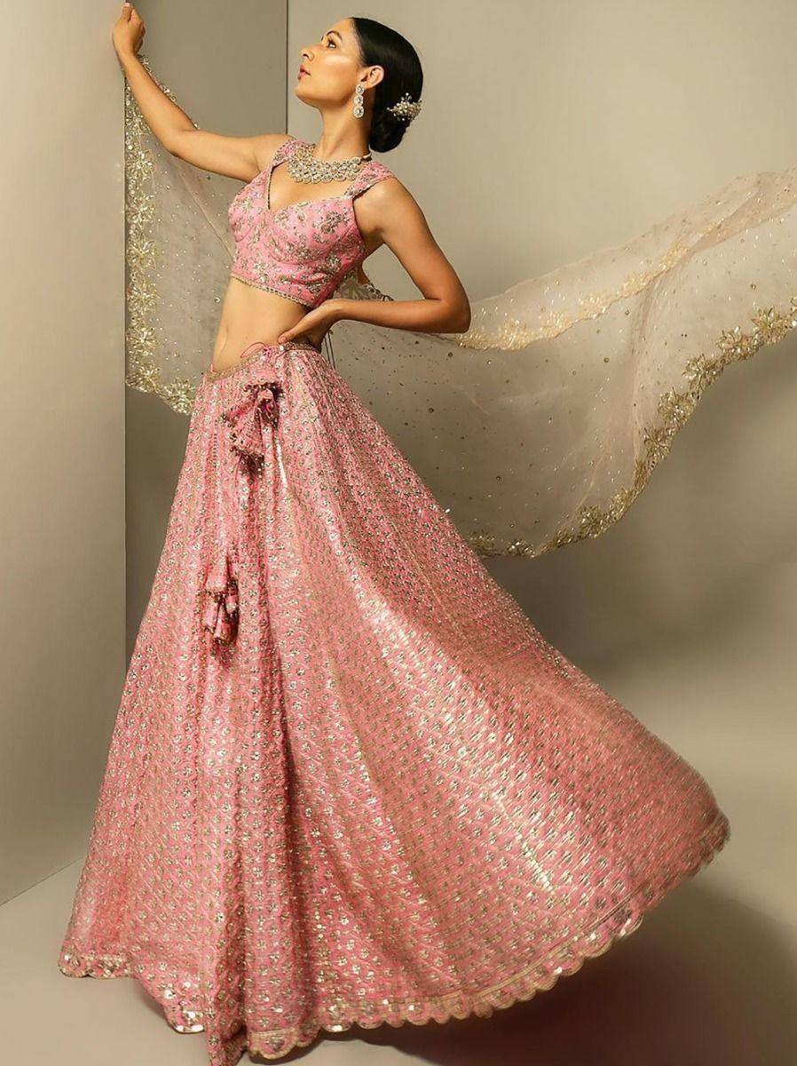 Pink designer lehenga choli with gold embroidery, perfect for Indian weddings and festive occasions.