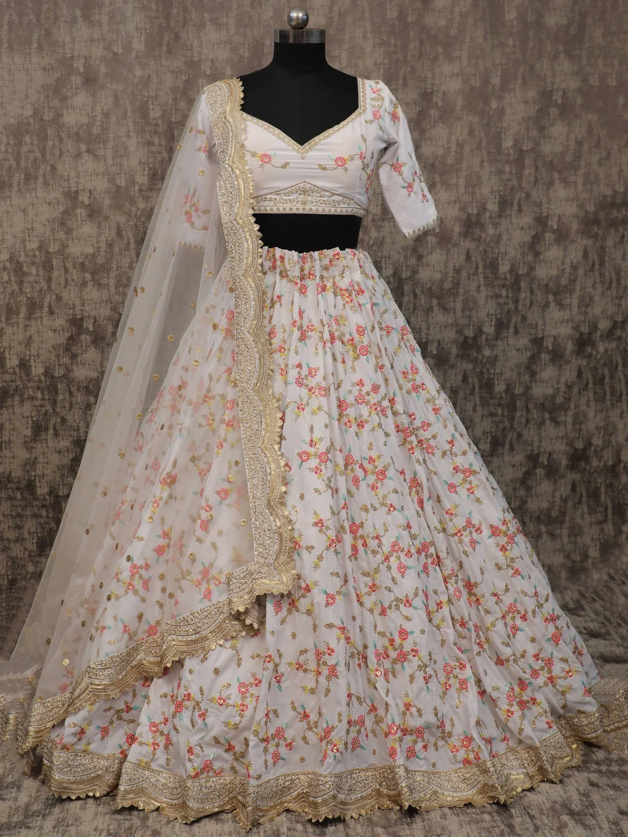 White floral embroidered lehenga choli with gold detailing and sheer dupatta, perfect for Indian weddings and festive occasions.