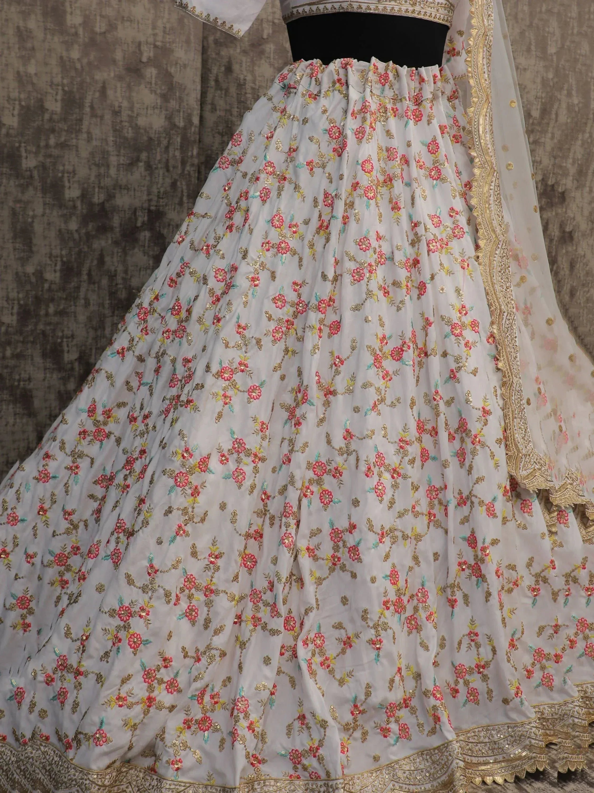 White lehenga choli with pink floral embroidery and gold detailing, perfect for Indian ethnic wear