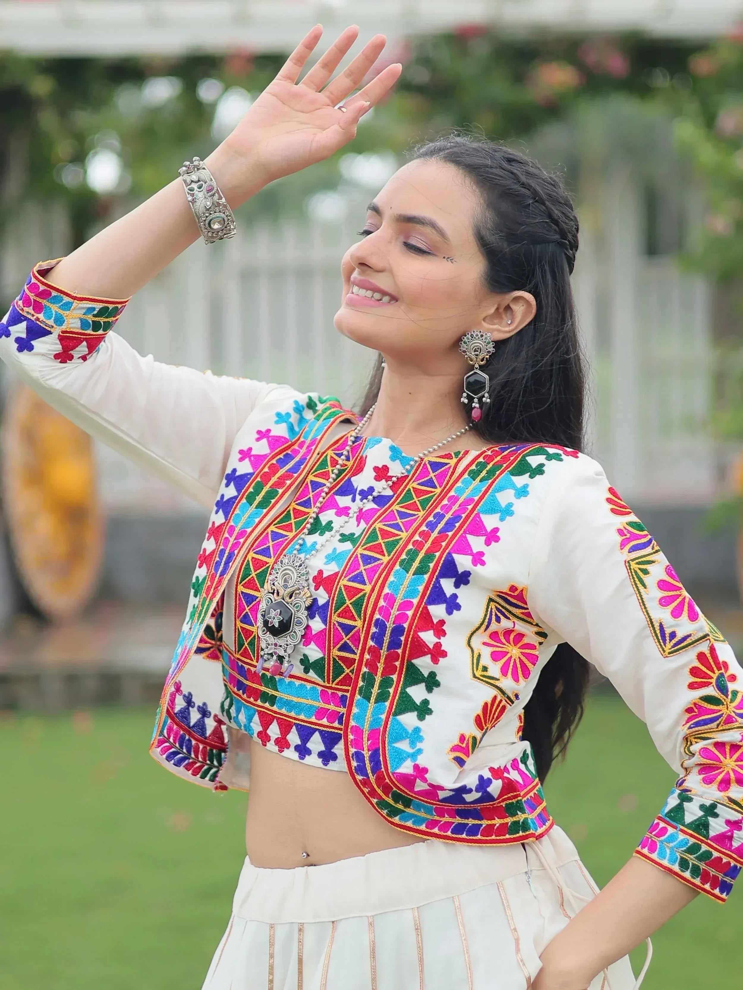 Woman in colorful embroidered white ethnic crop top and skirt, perfect for Indian festive wear or designer lehenga choli styling.