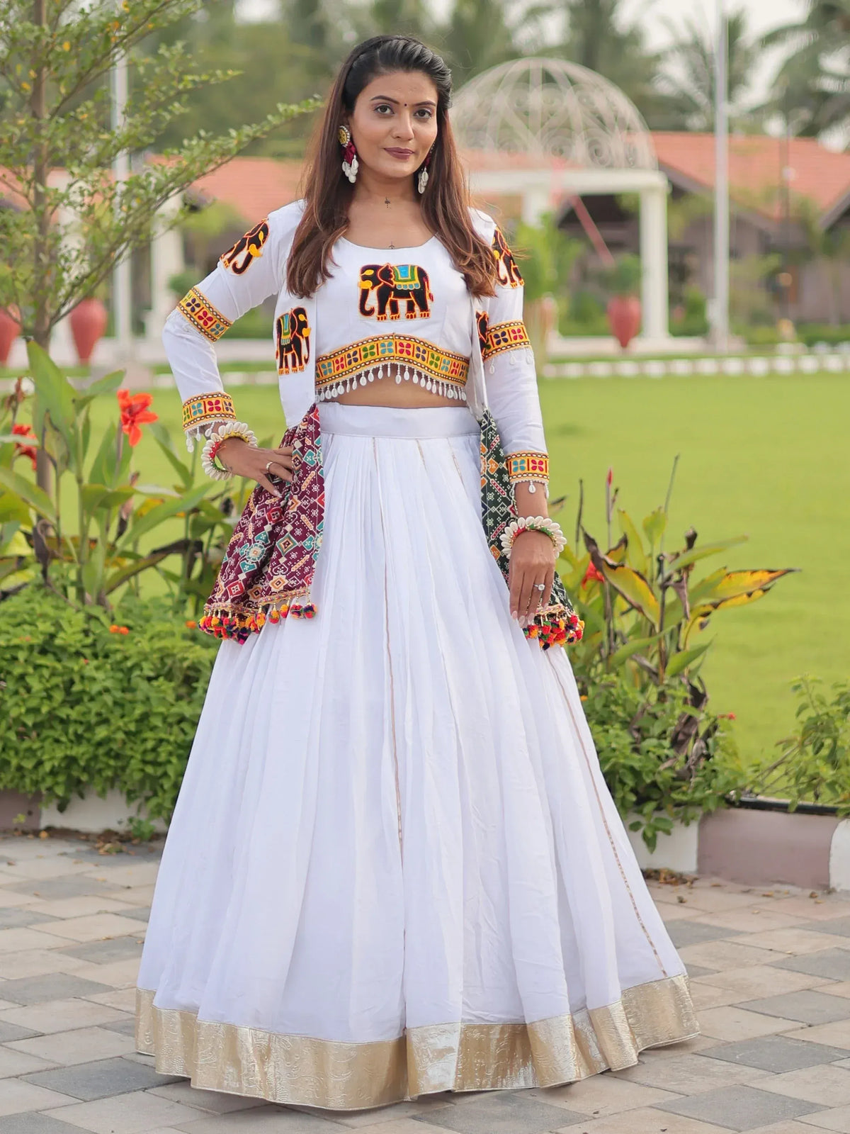 White ethnic lehenga choli with elephant embroidery and colorful dupatta, perfect for Indian festivals and weddings.