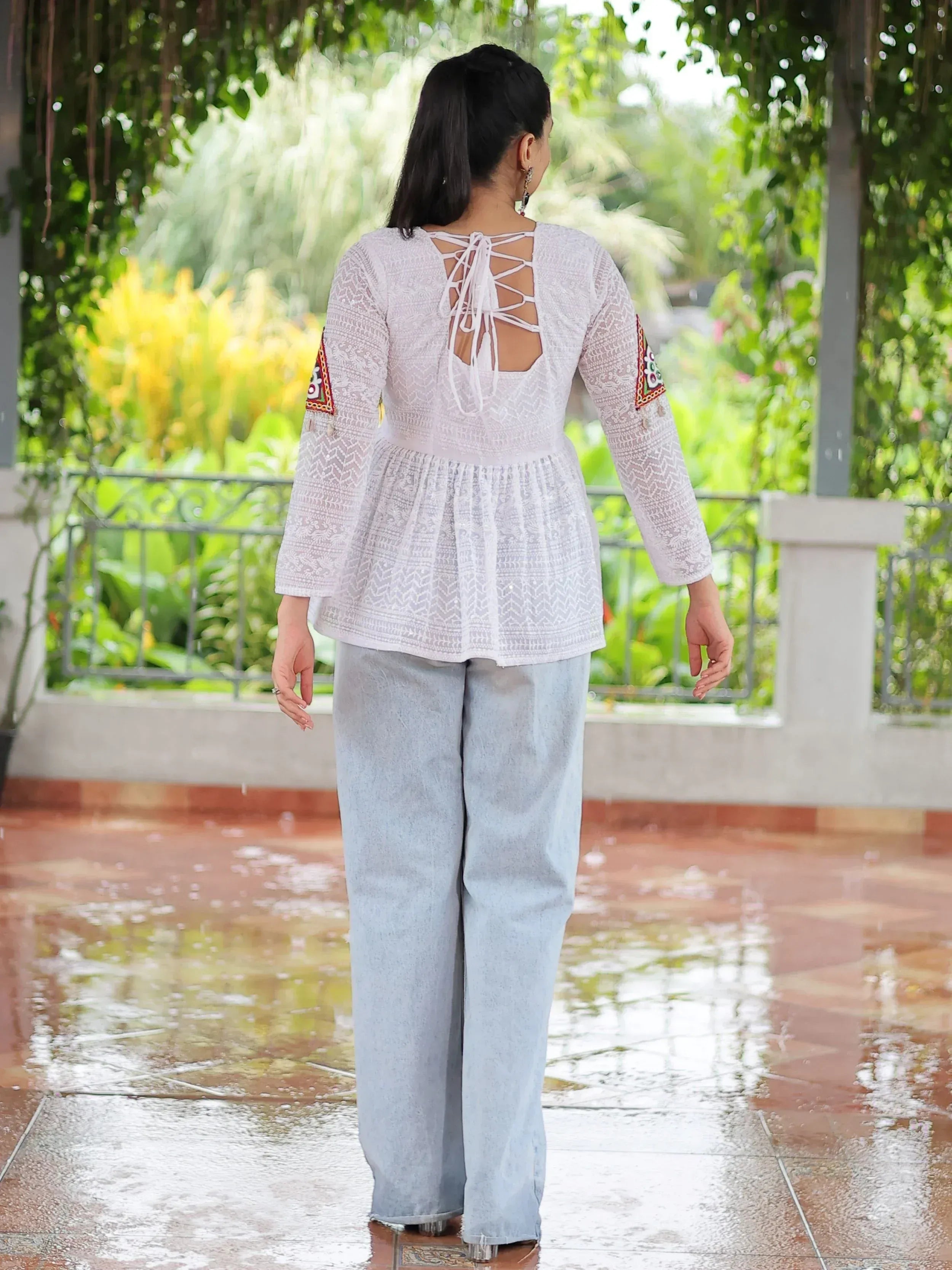 White embroidered ethnic top with back lace-up detail, paired with light blue palazzo pants, perfect for Indian wear.