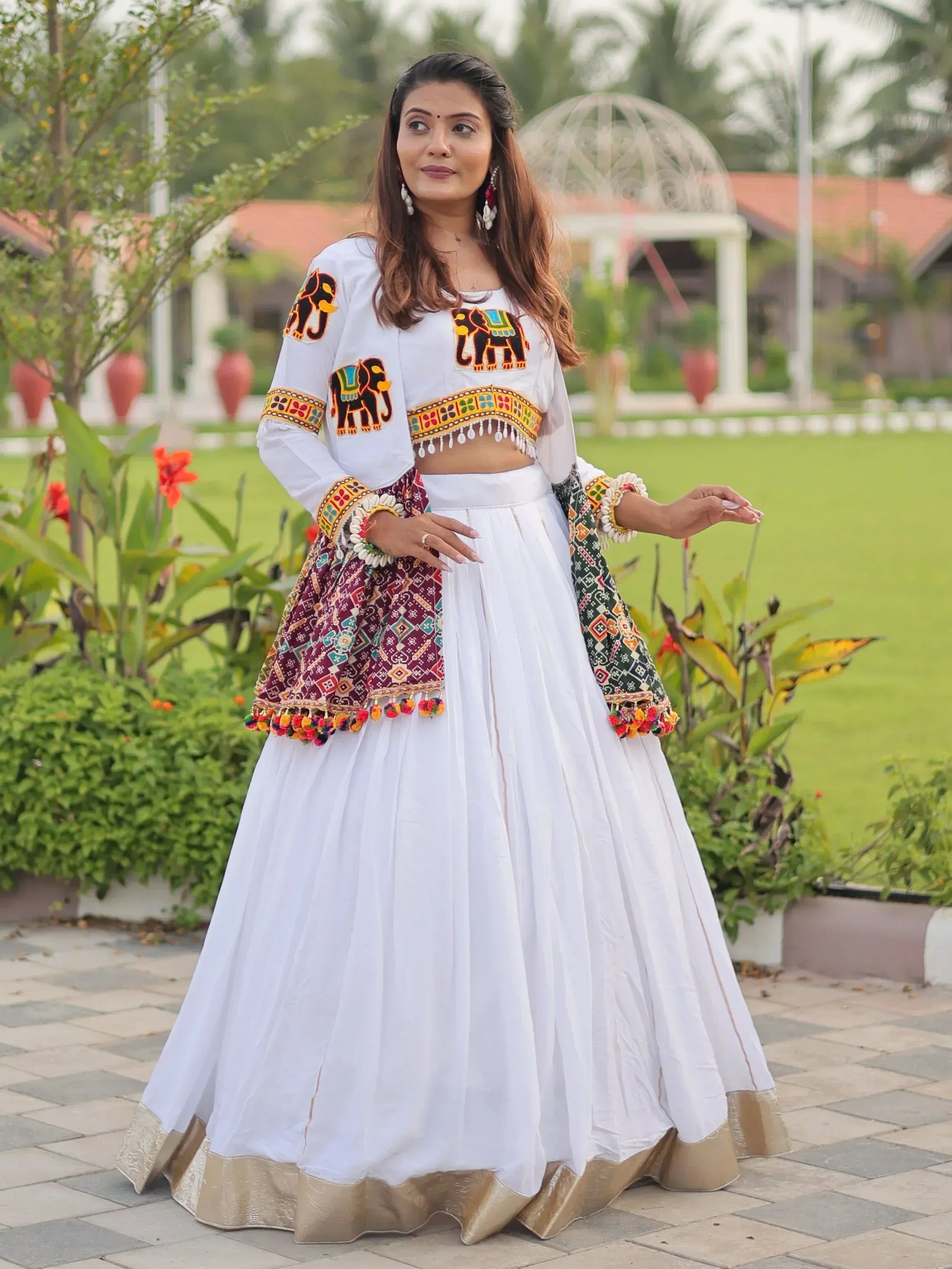 White ethnic lehenga choli with elephant embroidery and colorful dupatta, perfect for Indian festivals and weddings.