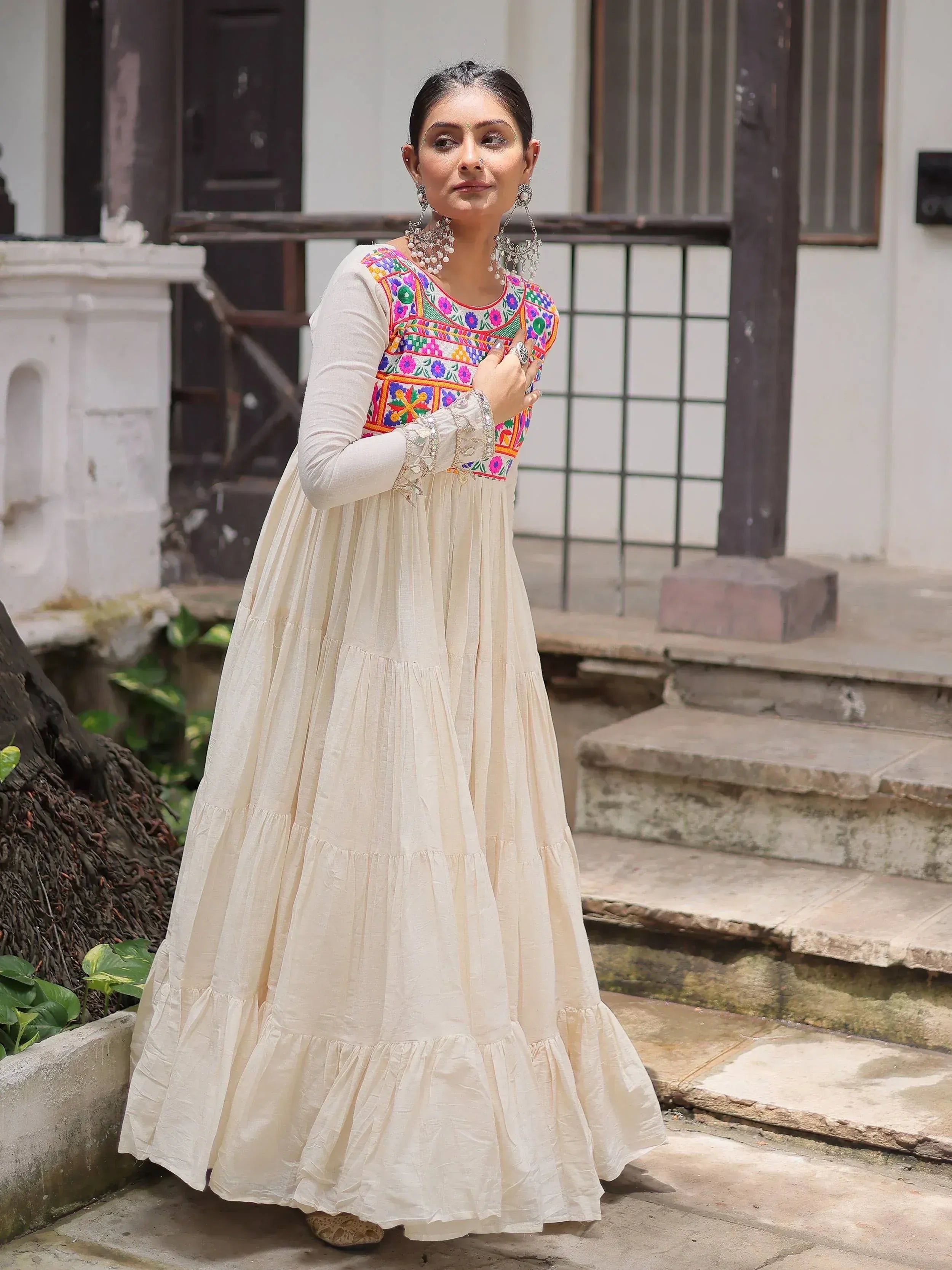 Cream ethnic gown with colorful floral embroidery, perfect for Indian festive wear and designer occasions.