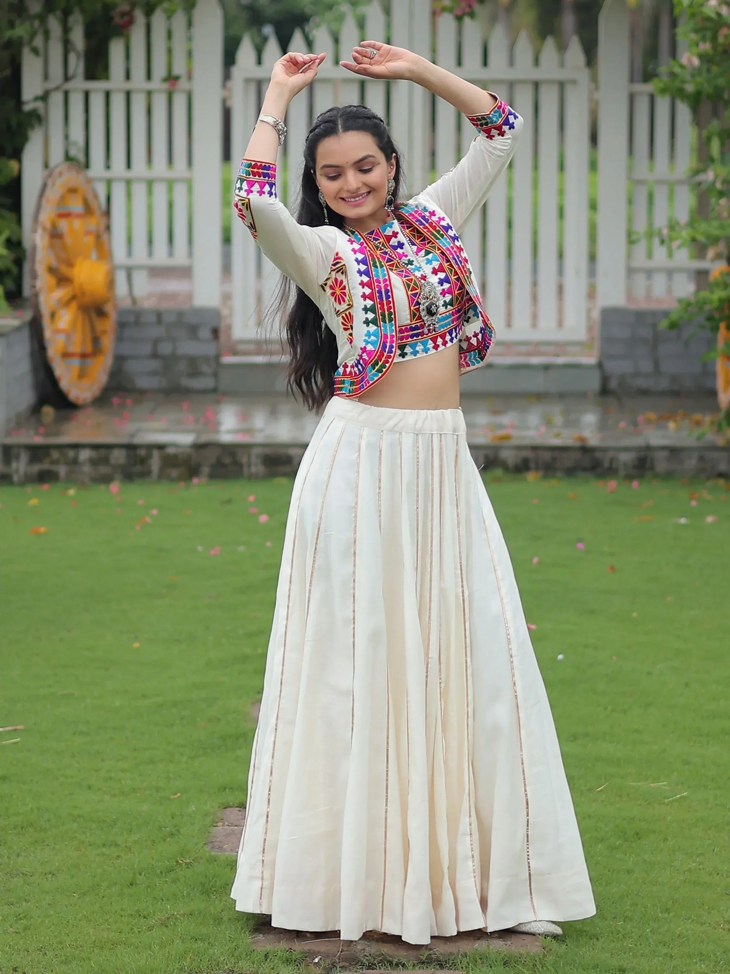 White ethnic crop top with colorful embroidery paired with pleated skirt, perfect for Indian festive wear