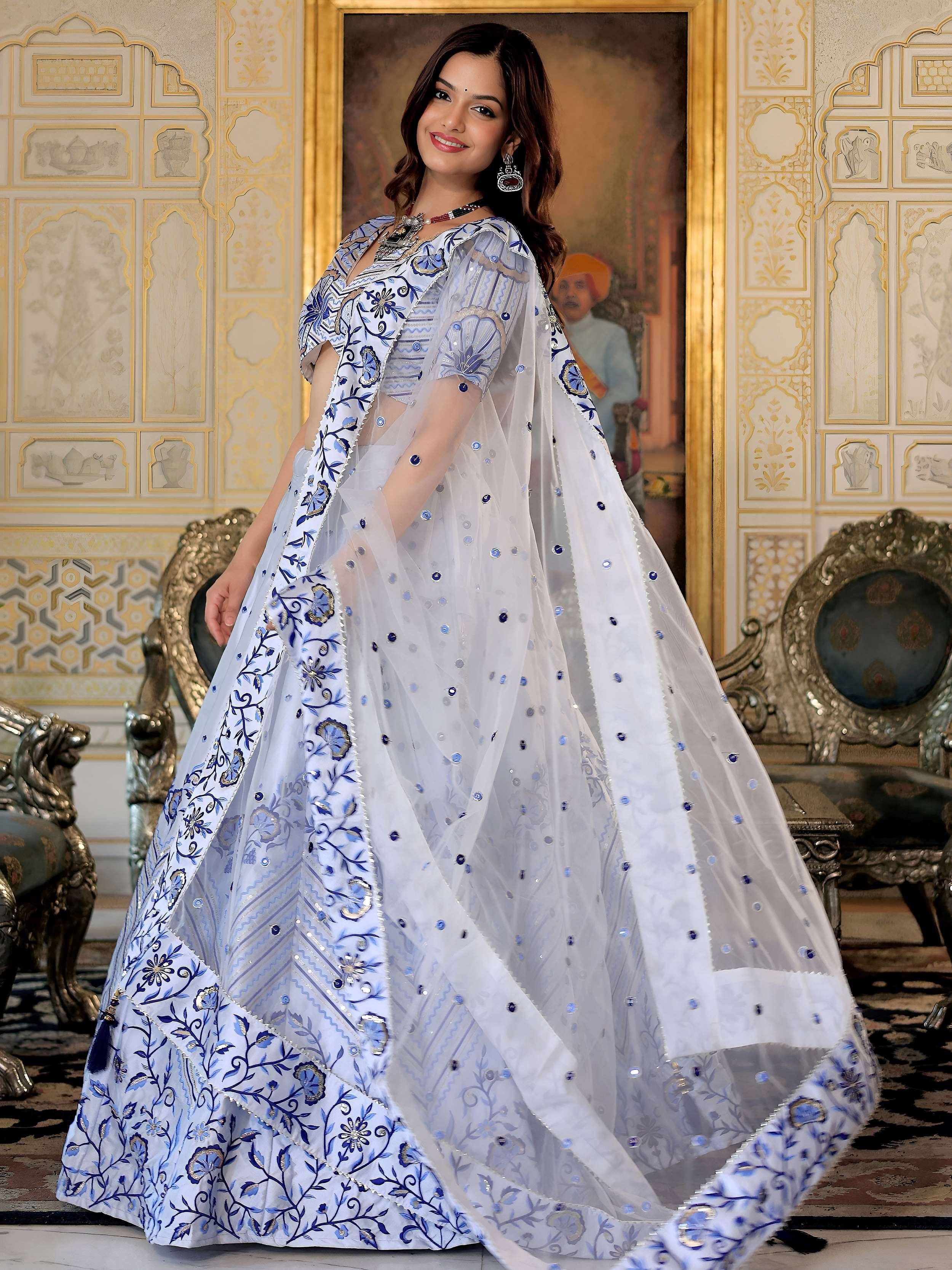 Elegant white and blue embroidered lehenga choli with sheer dupatta, perfect for Indian ethnic wear occasions.