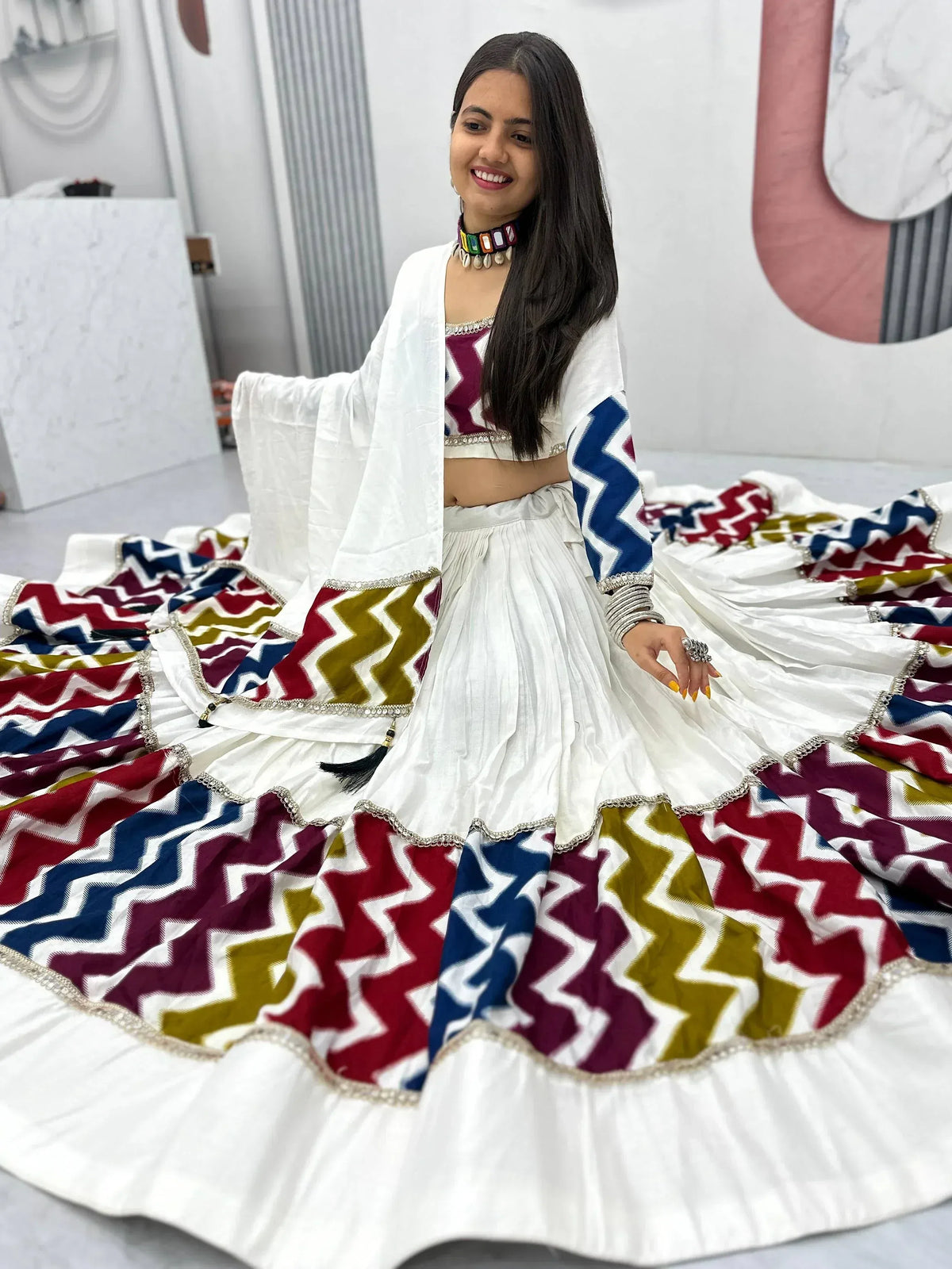 White lehenga choli with colorful zigzag print, perfect for Indian ethnic wear and festive occasions.