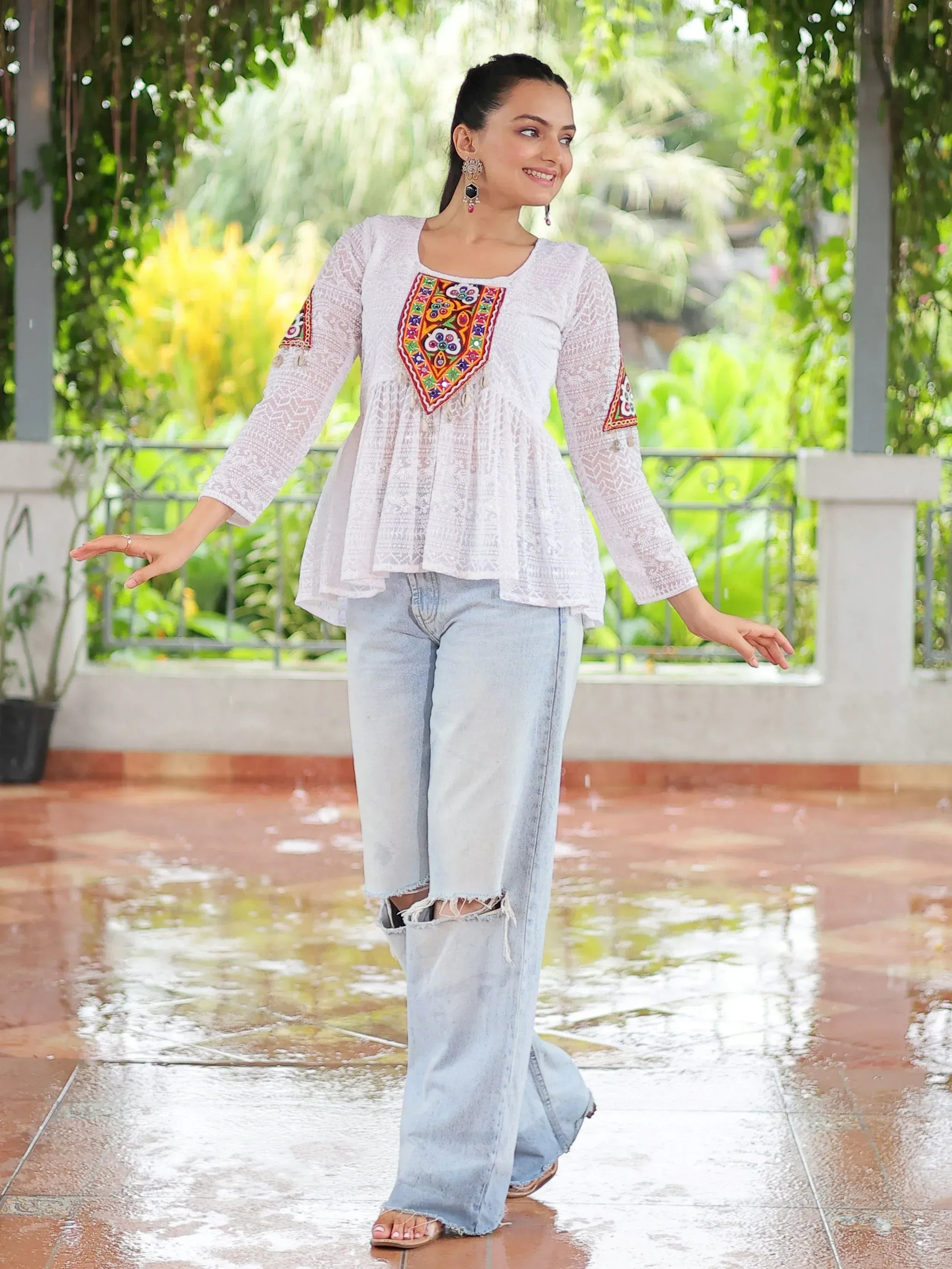 White embroidered ethnic top with lace detailing paired with ripped jeans, perfect for casual Indian wear.