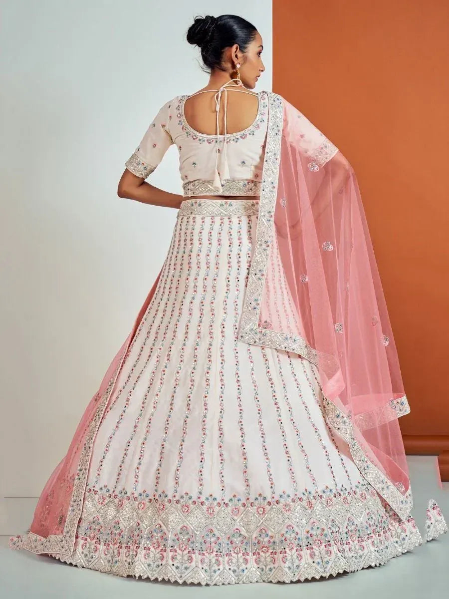 Elegant ivory lehenga choli with pink embroidery and sheer dupatta, perfect for Indian weddings or festive occasions.