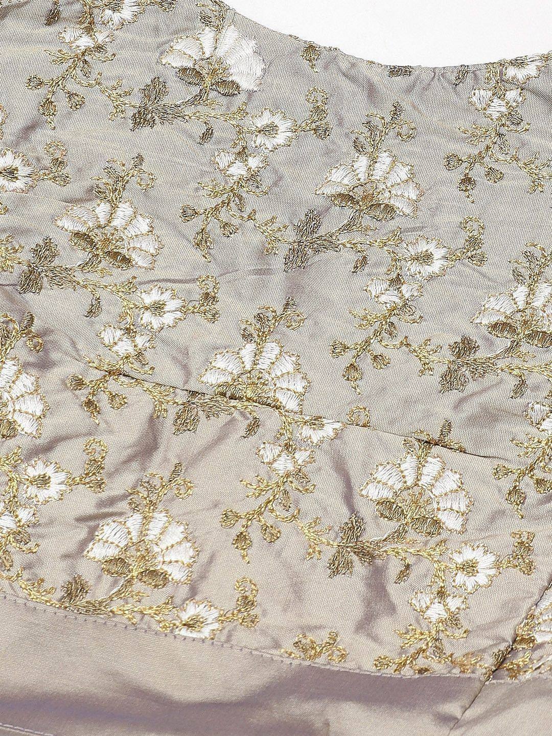 Elegant silver lehenga choli with gold and white floral embroidery, perfect for Indian ethnic wear.