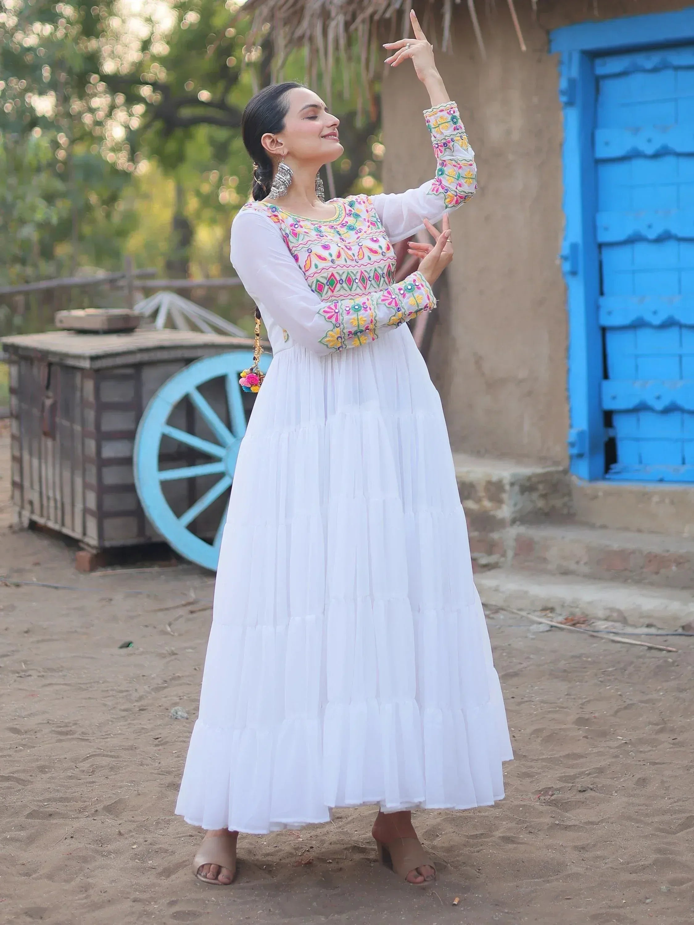 White embroidered ethnic gown with colorful floral patterns, perfect for Indian festive occasions