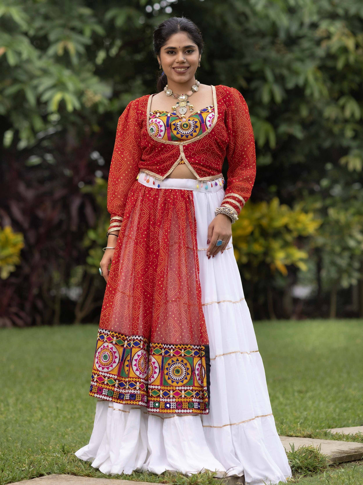 Woman in red and white embroidered ethnic lehenga choli with mirror work, perfect for Indian festivals and celebrations