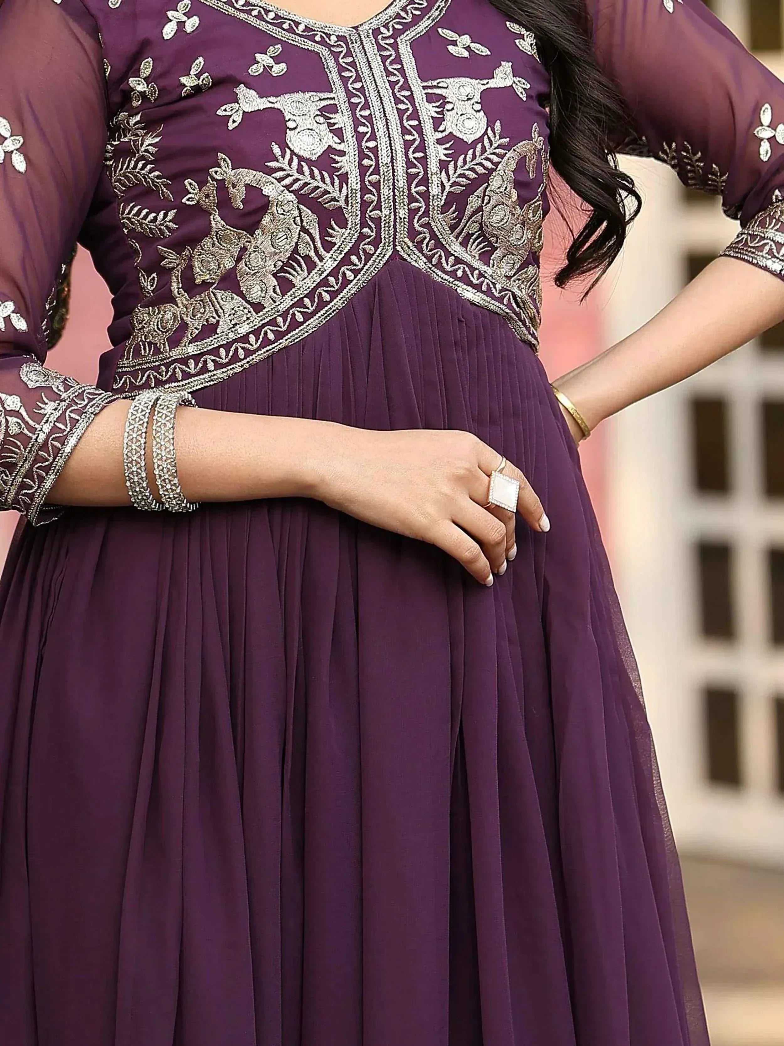 Purple ethnic gown with intricate silver embroidery and pleated skirt, perfect for Indian occasions.