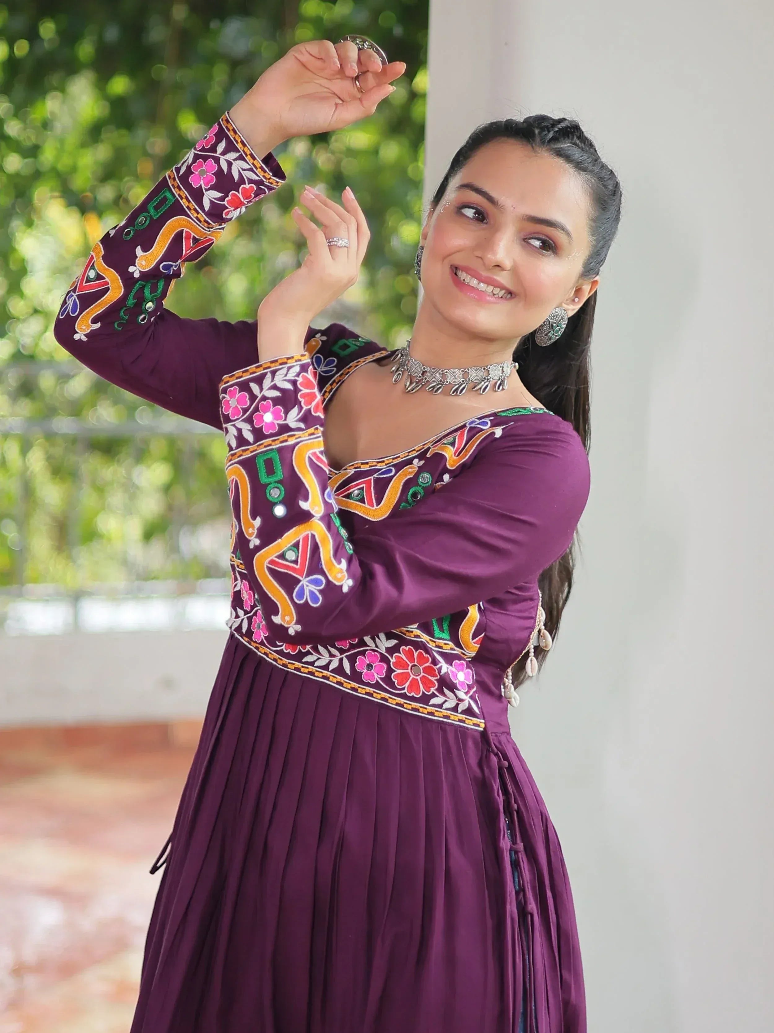 Purple embroidered ethnic gown with floral patterns and silver jewelry