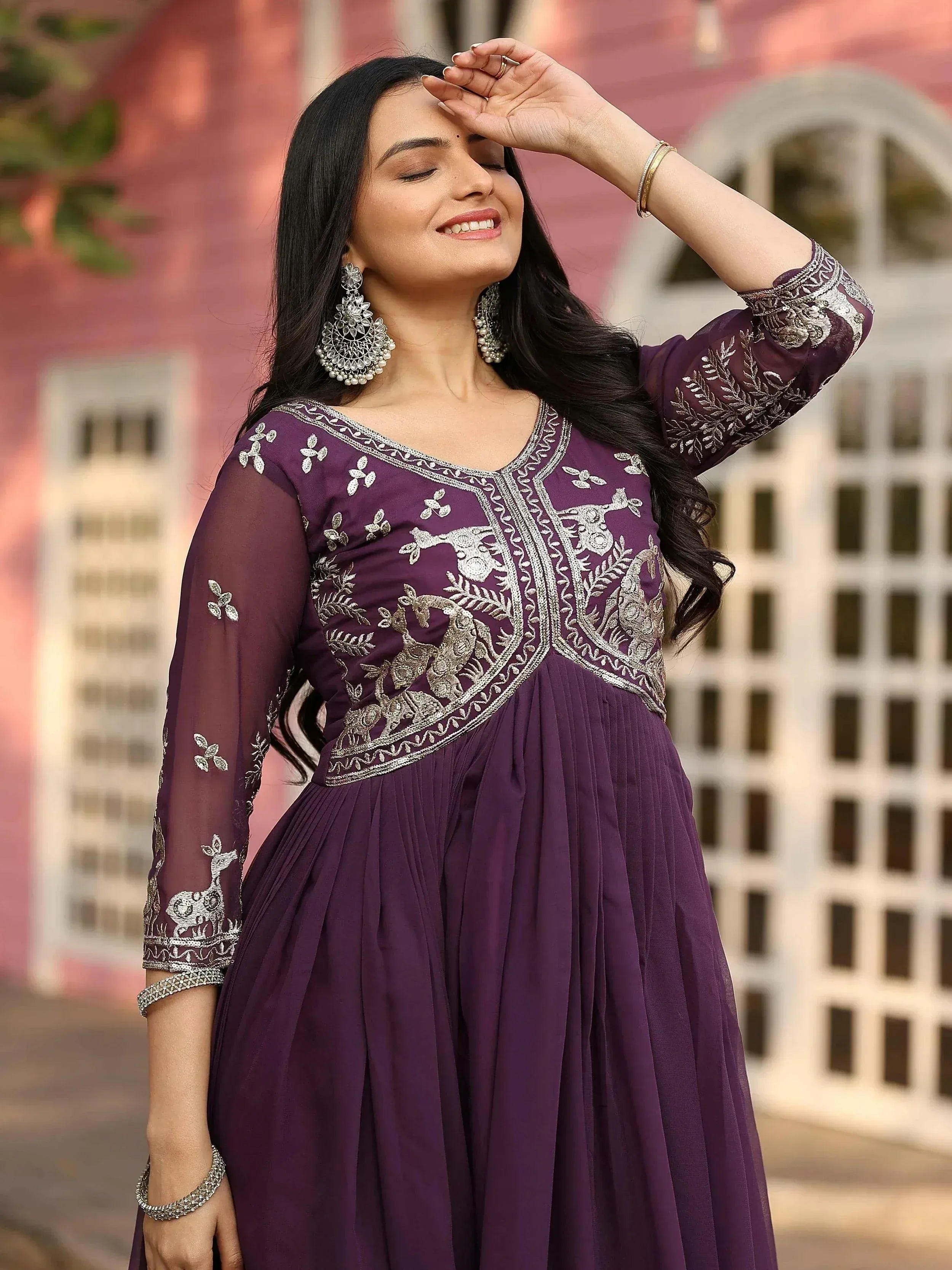 Woman in purple embroidered ethnic gown with peacock design, perfect for Indian occasions