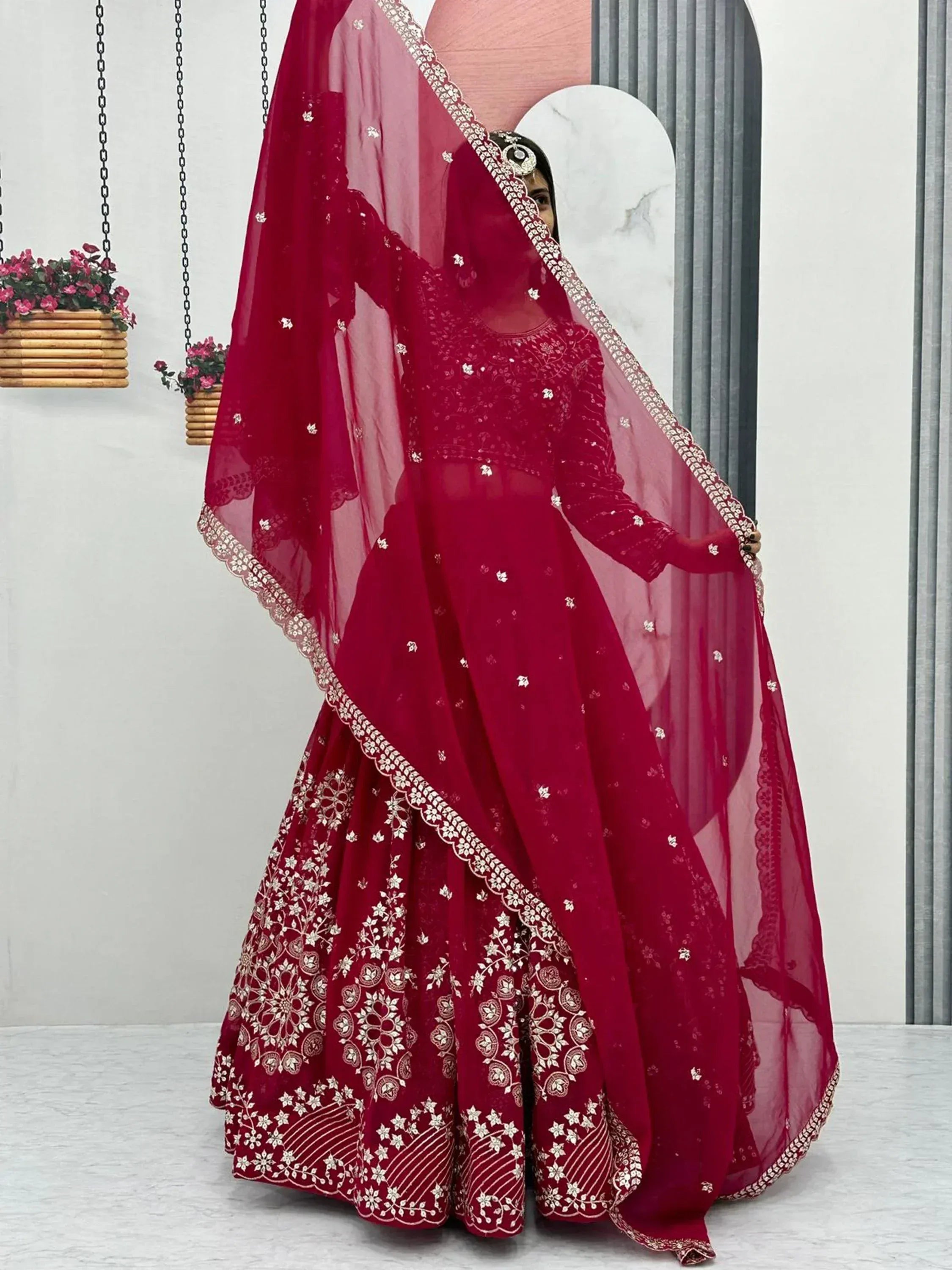 Elegant maroon lehenga choli with gold embroidery and sheer dupatta, perfect for Indian weddings and festive occasions.