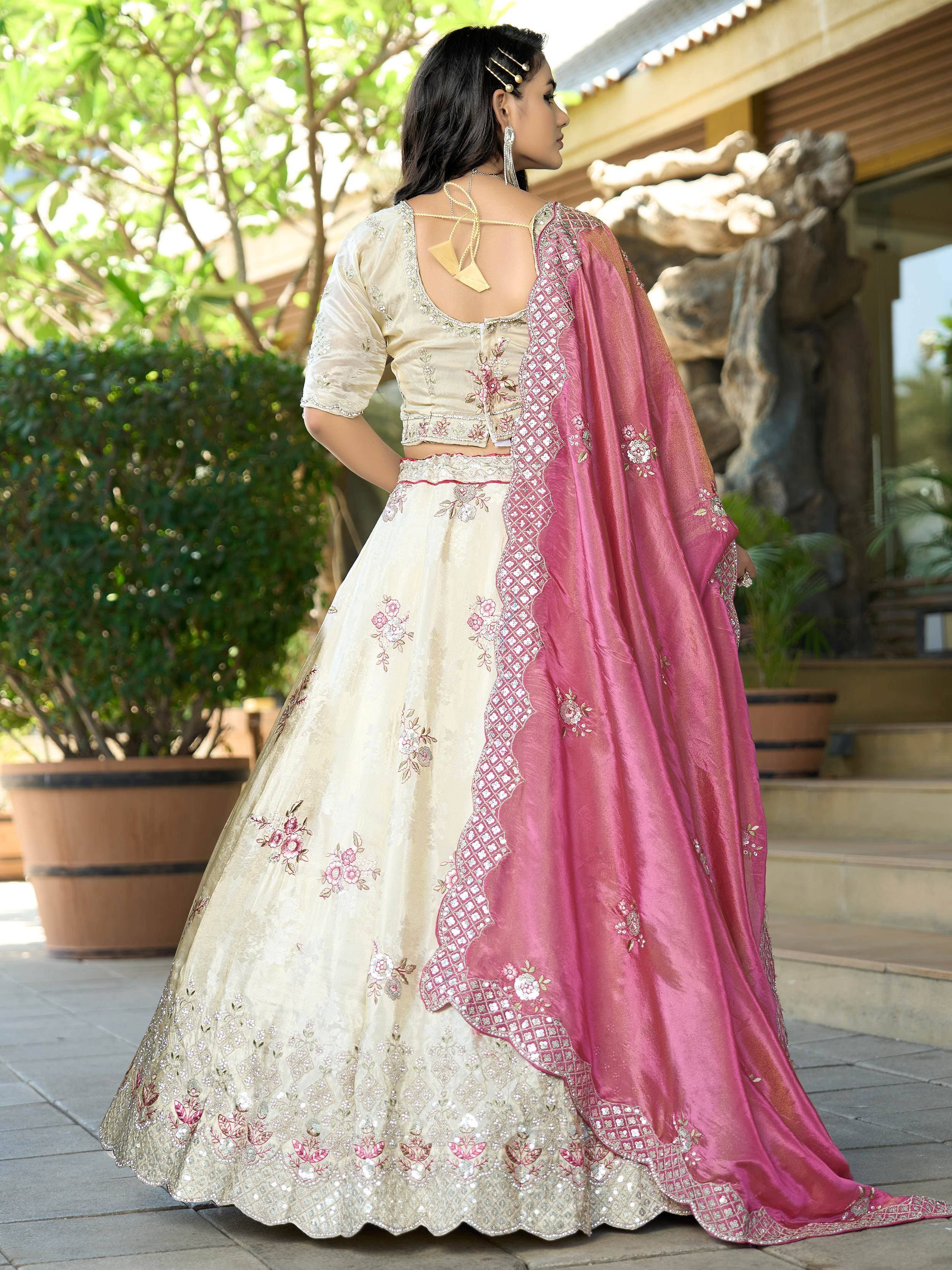 Elegant cream lehenga choli with pink dupatta, floral embroidery, and scalloped hem for Indian ethnic wear