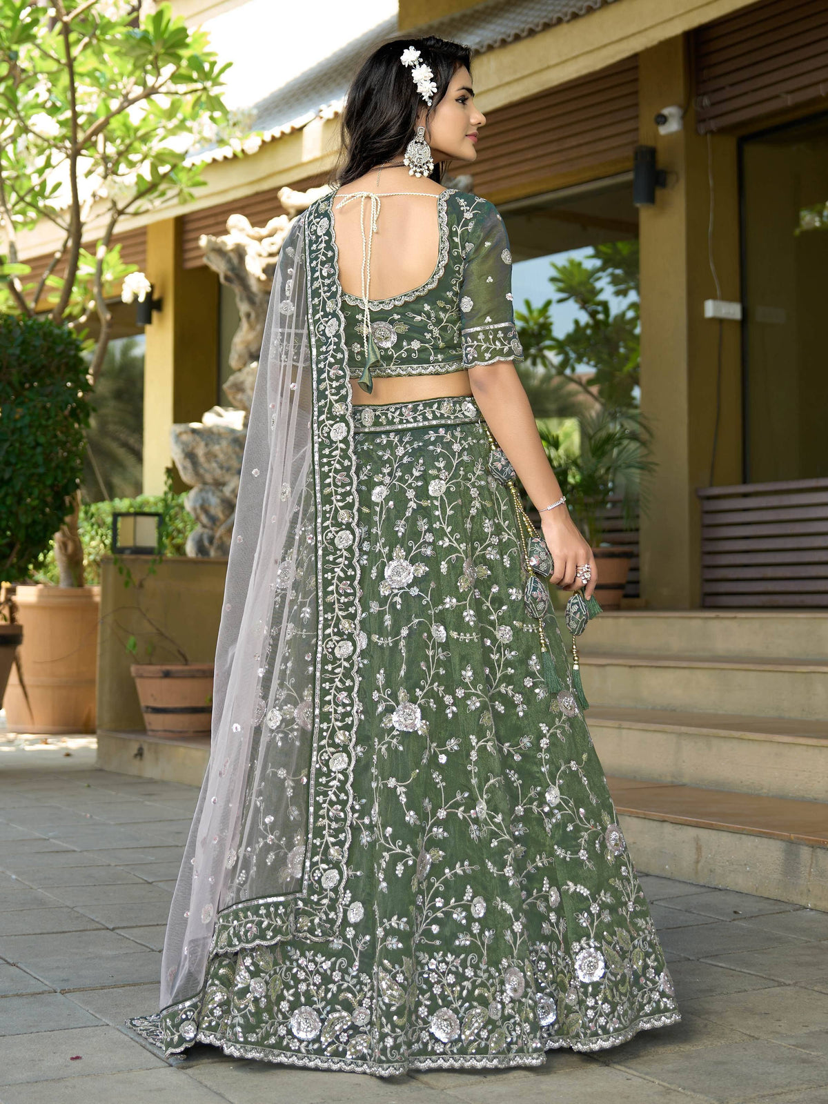 Green embroidered lehenga choli with floral design, sheer dupatta, and back tie detail for Indian ethnic wear
