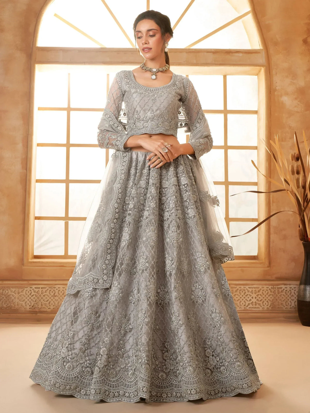 Elegant grey embroidered lehenga choli with sheer sleeves, perfect for Indian weddings and festive occasions.