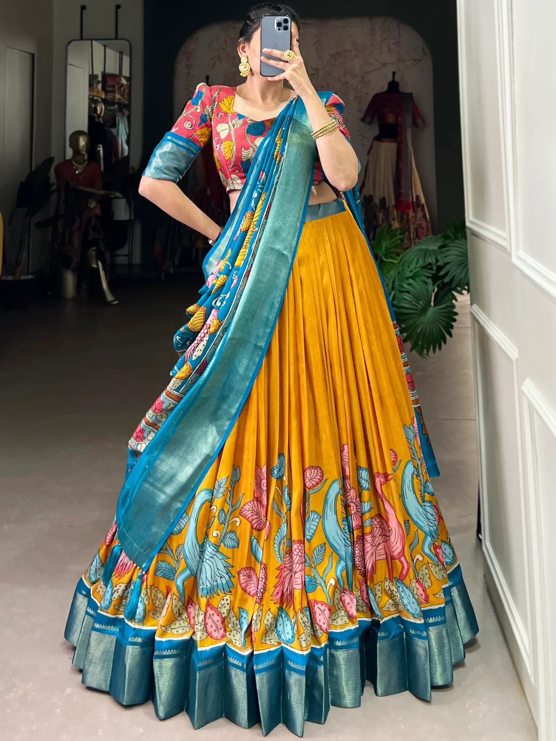 Woman in vibrant yellow floral lehenga choli with blue dupatta, Indian ethnic wear