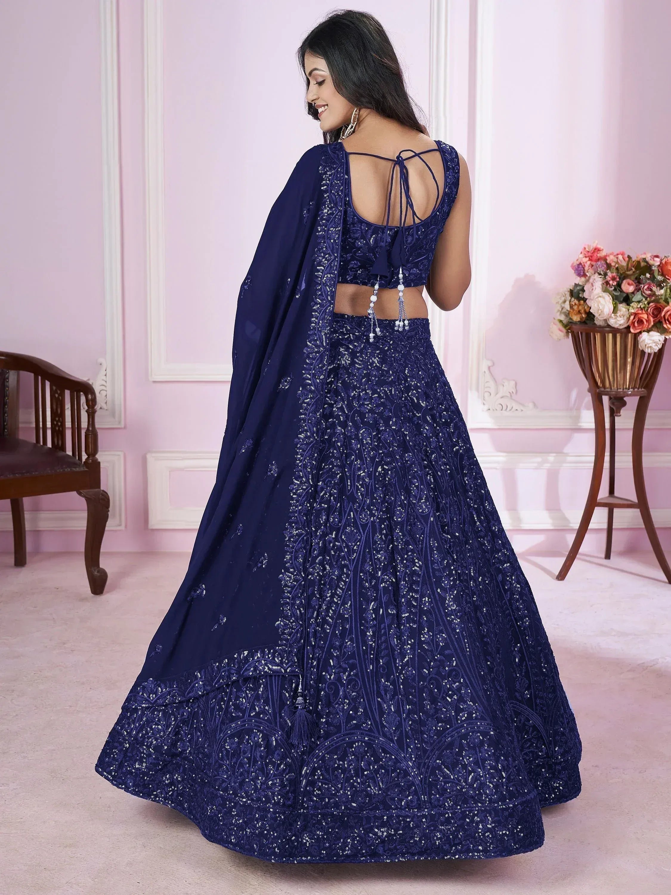 Navy blue designer lehenga choli with intricate embroidery and back tie detail, perfect for Indian ethnic occasions.