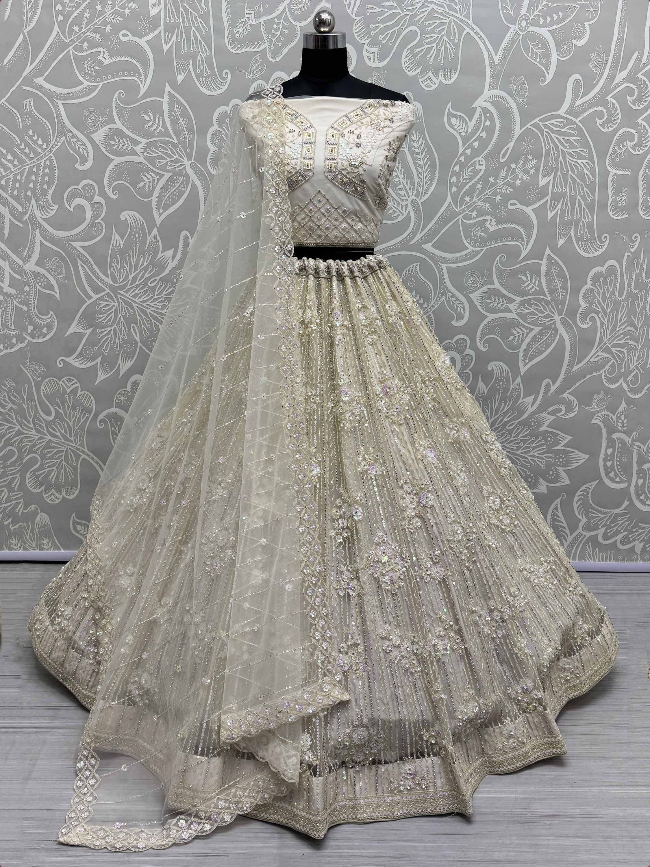 Elegant ivory lehenga choli with heavy embroidery and sequin work, perfect for weddings and festive occasions.
