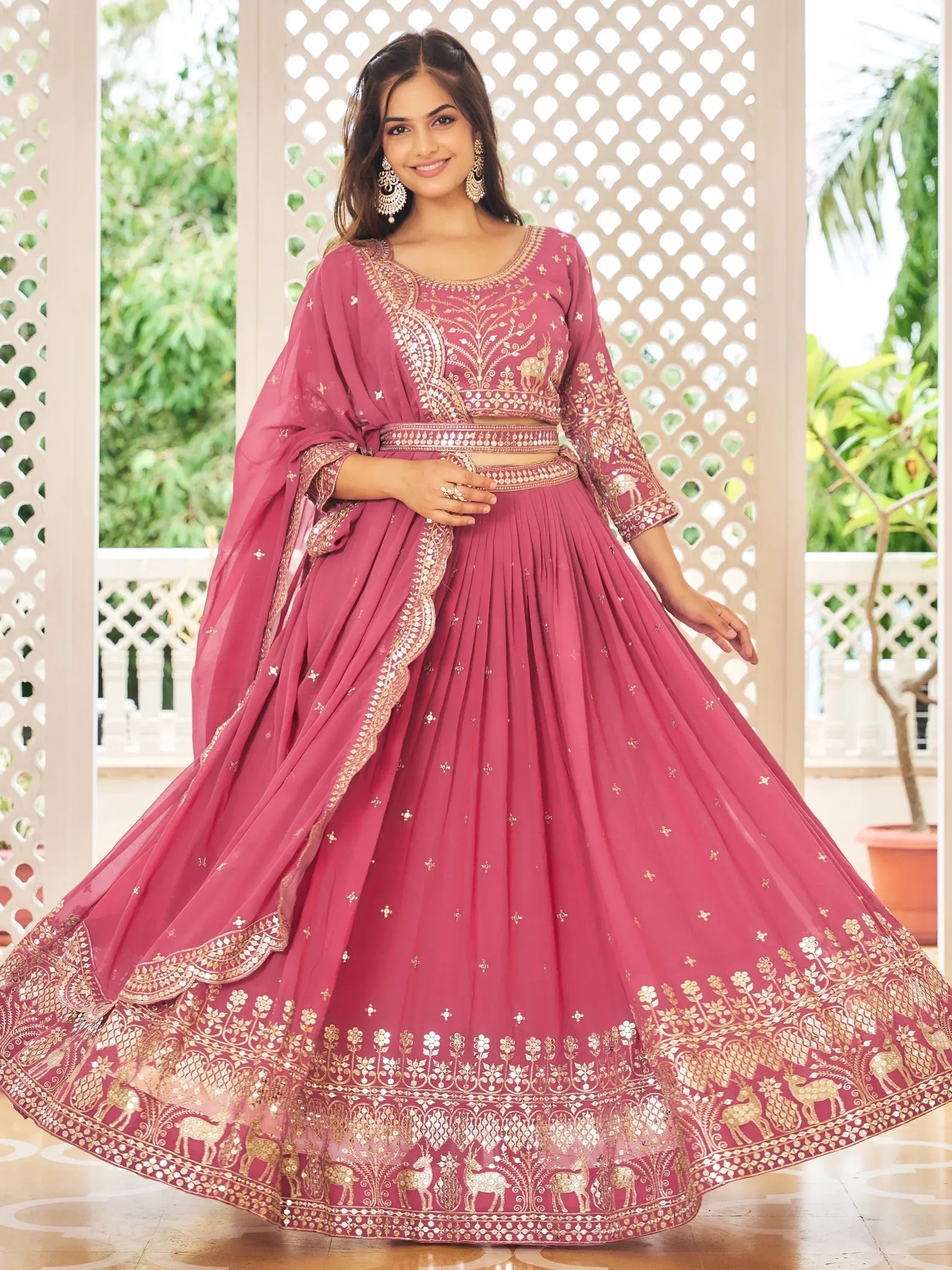 Pink designer lehenga choli with gold embroidery and deer motifs, perfect for Indian ethnic wear occasions