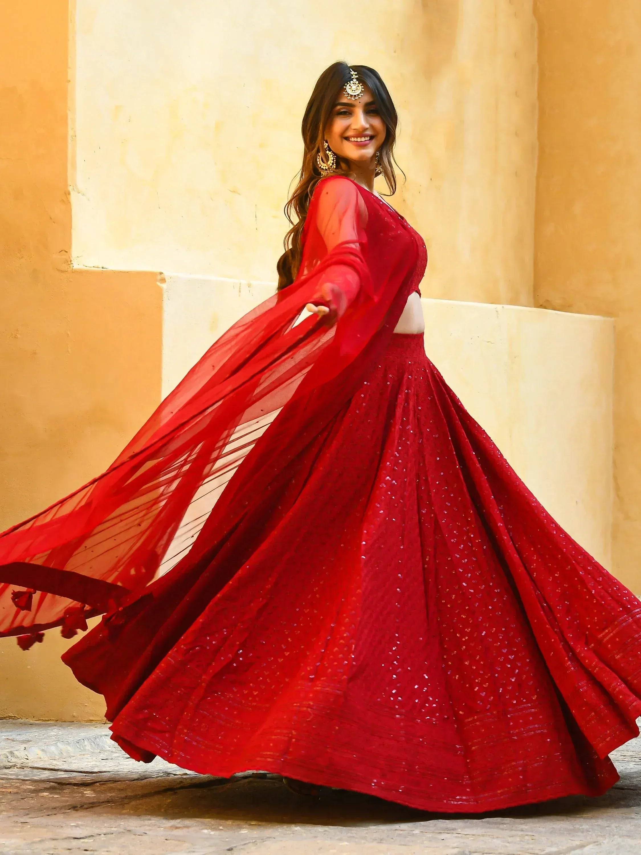 Red sequined lehenga choli with sheer dupatta, perfect for Indian weddings and festive occasions.