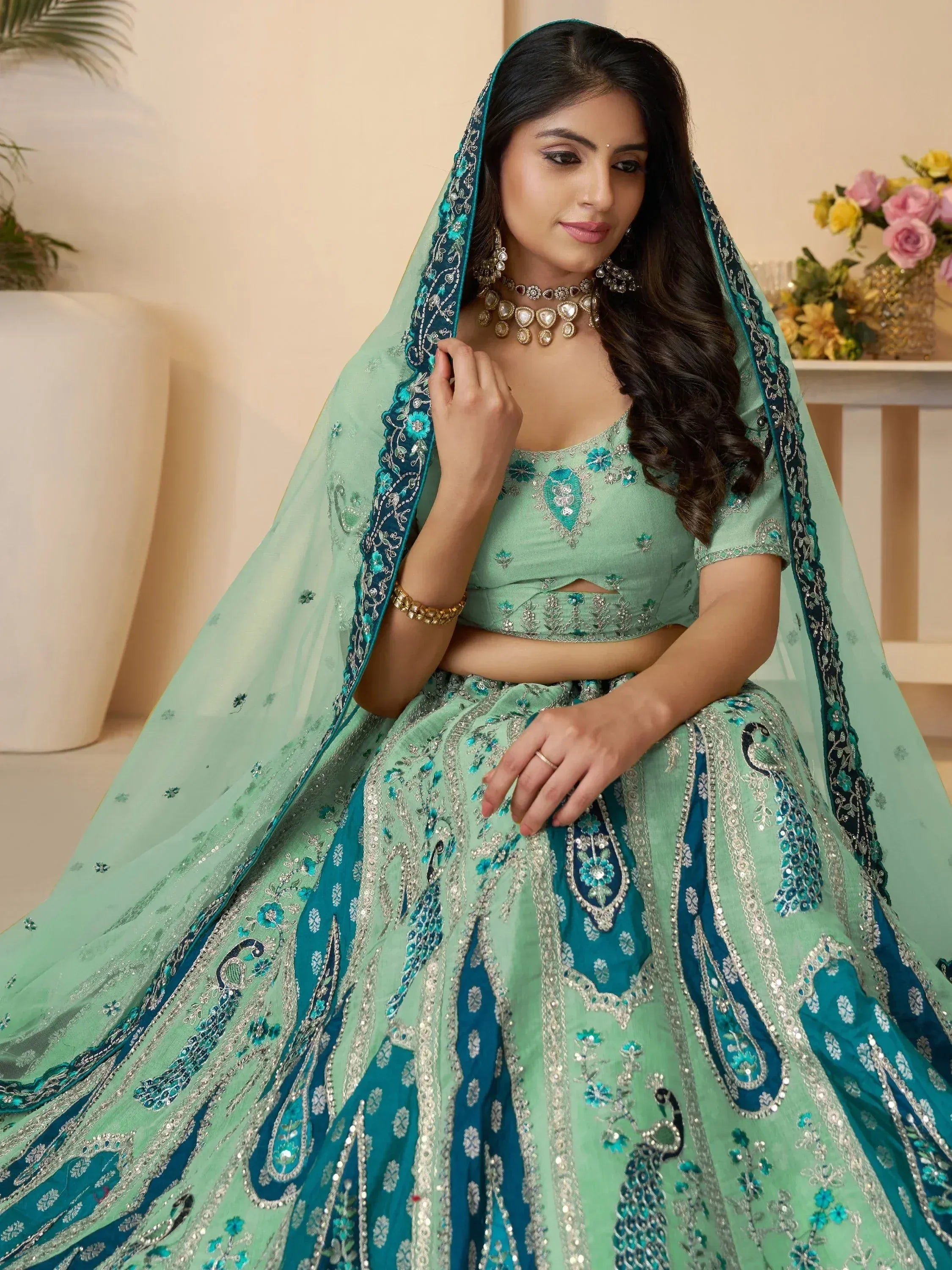 Mint green designer lehenga choli with peacock embroidery and net dupatta, perfect for weddings and festivals.