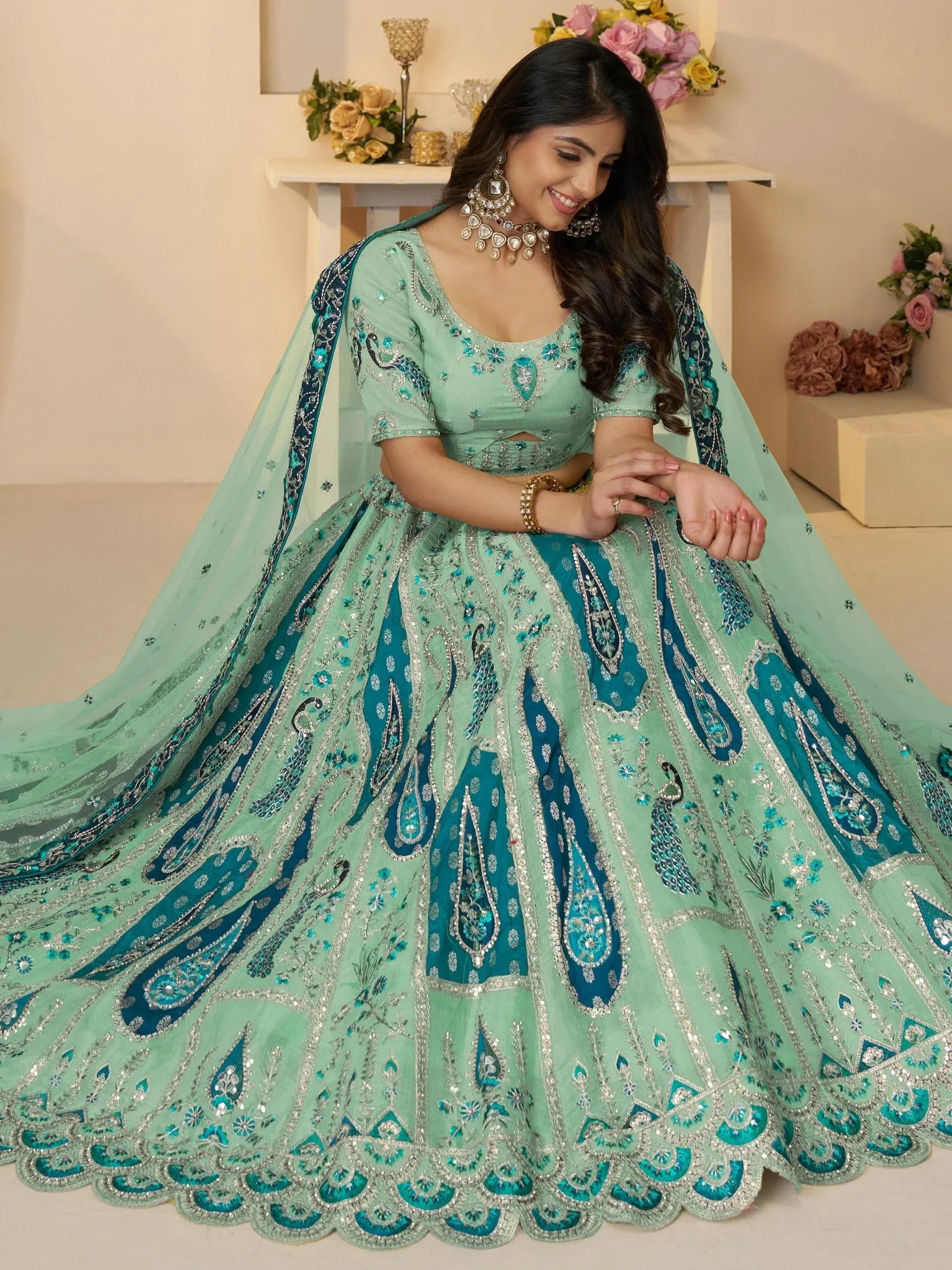 Mint green designer lehenga choli with peacock embroidery and sequin work, perfect for Indian weddings and festive occasions.