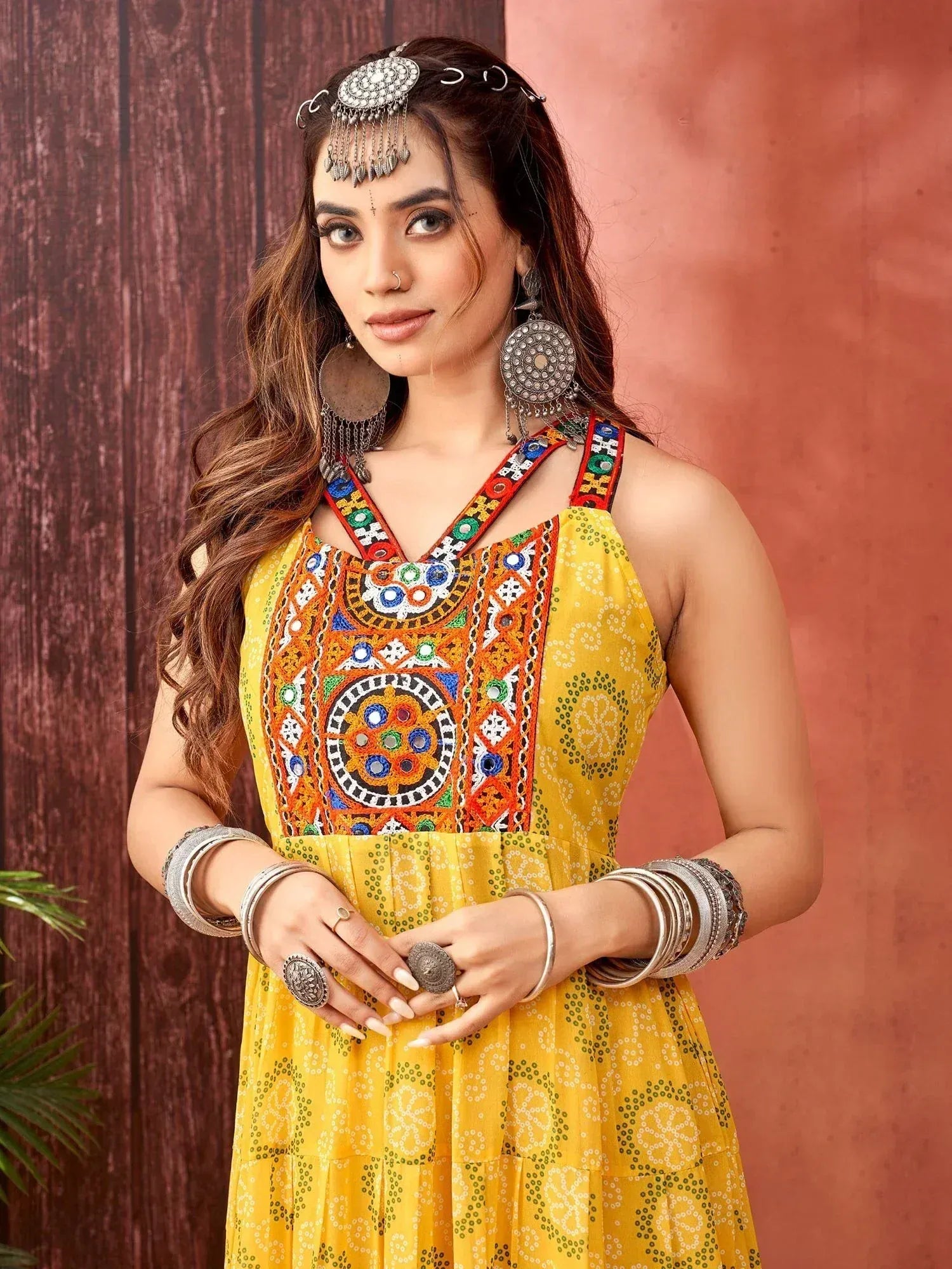 Yellow embroidered ethnic gown with mirror work and traditional jewelry