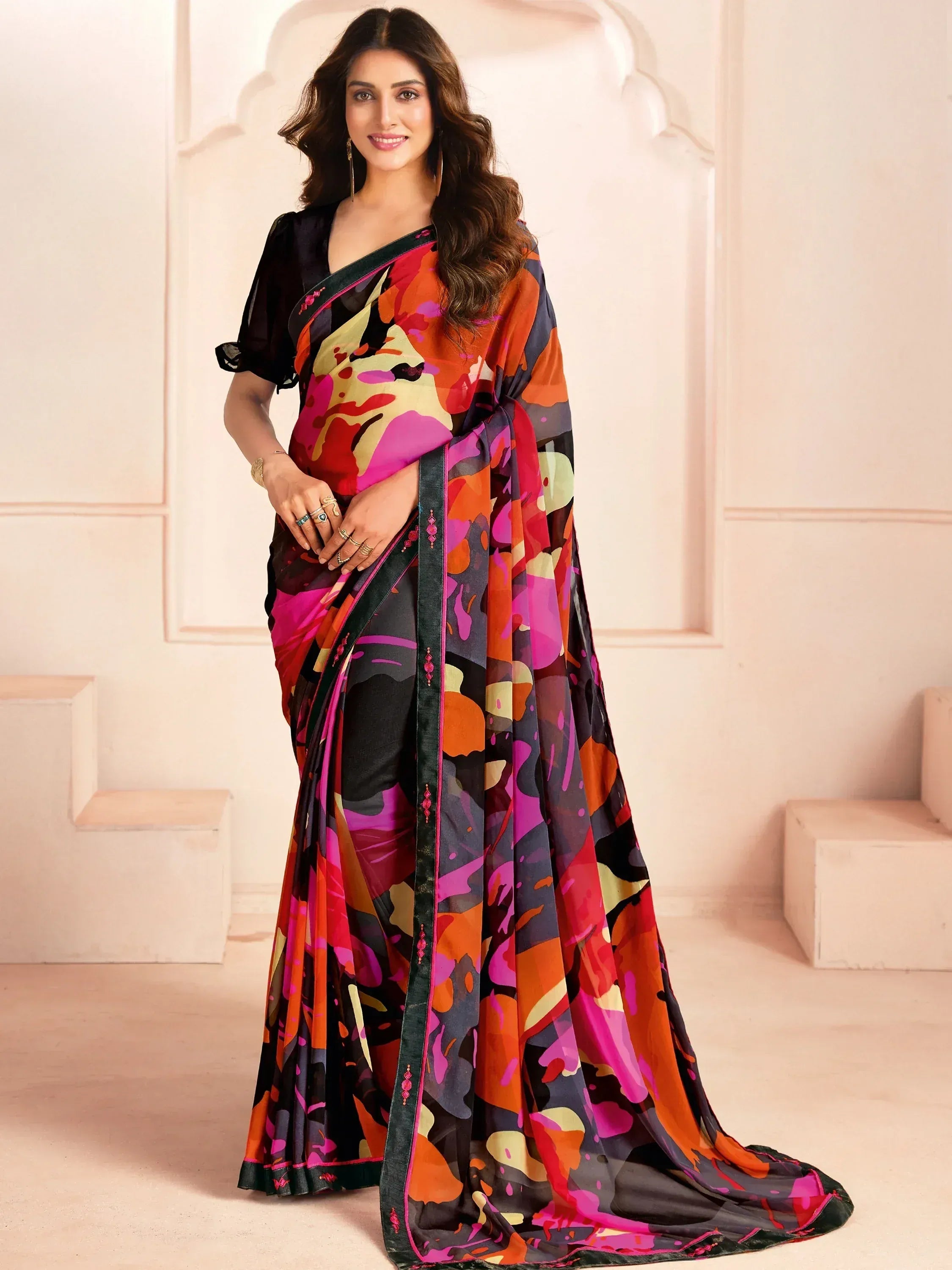 Woman in vibrant printed saree with black blouse, ethnic Indian wear for festive occasions