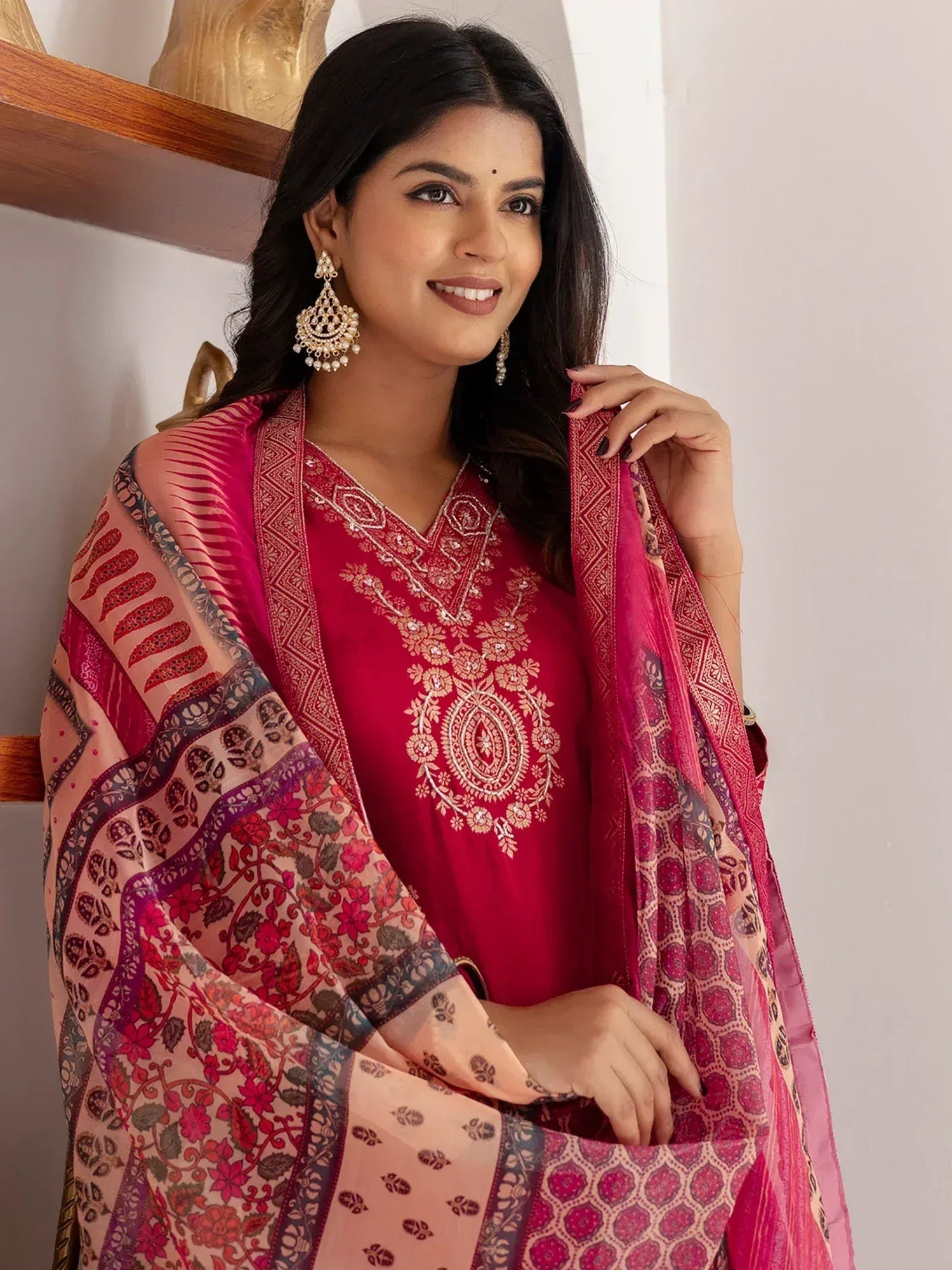 Woman in red embroidered ethnic salwar kameez with floral dupatta, traditional Indian wear