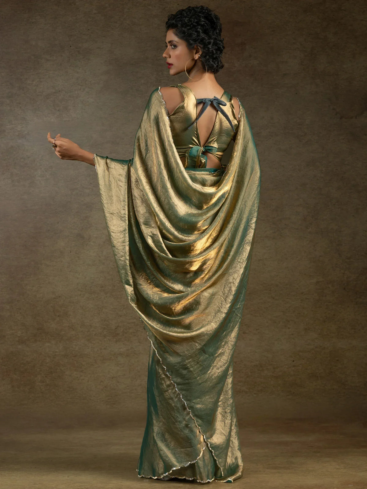Elegant green and gold saree with backless blouse, perfect for Indian ethnic wear occasions