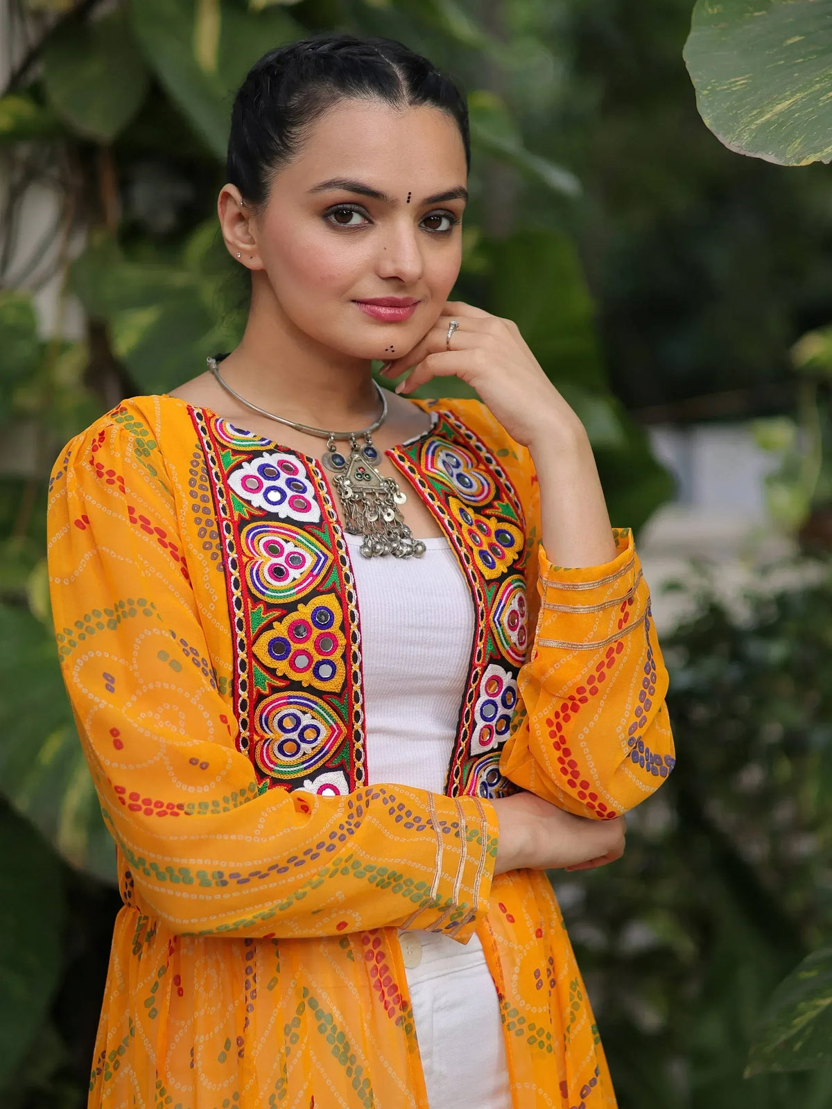 Vibrant yellow embroidered ethnic kurta with colorful mirror work, styled with white inner and silver jewelry.