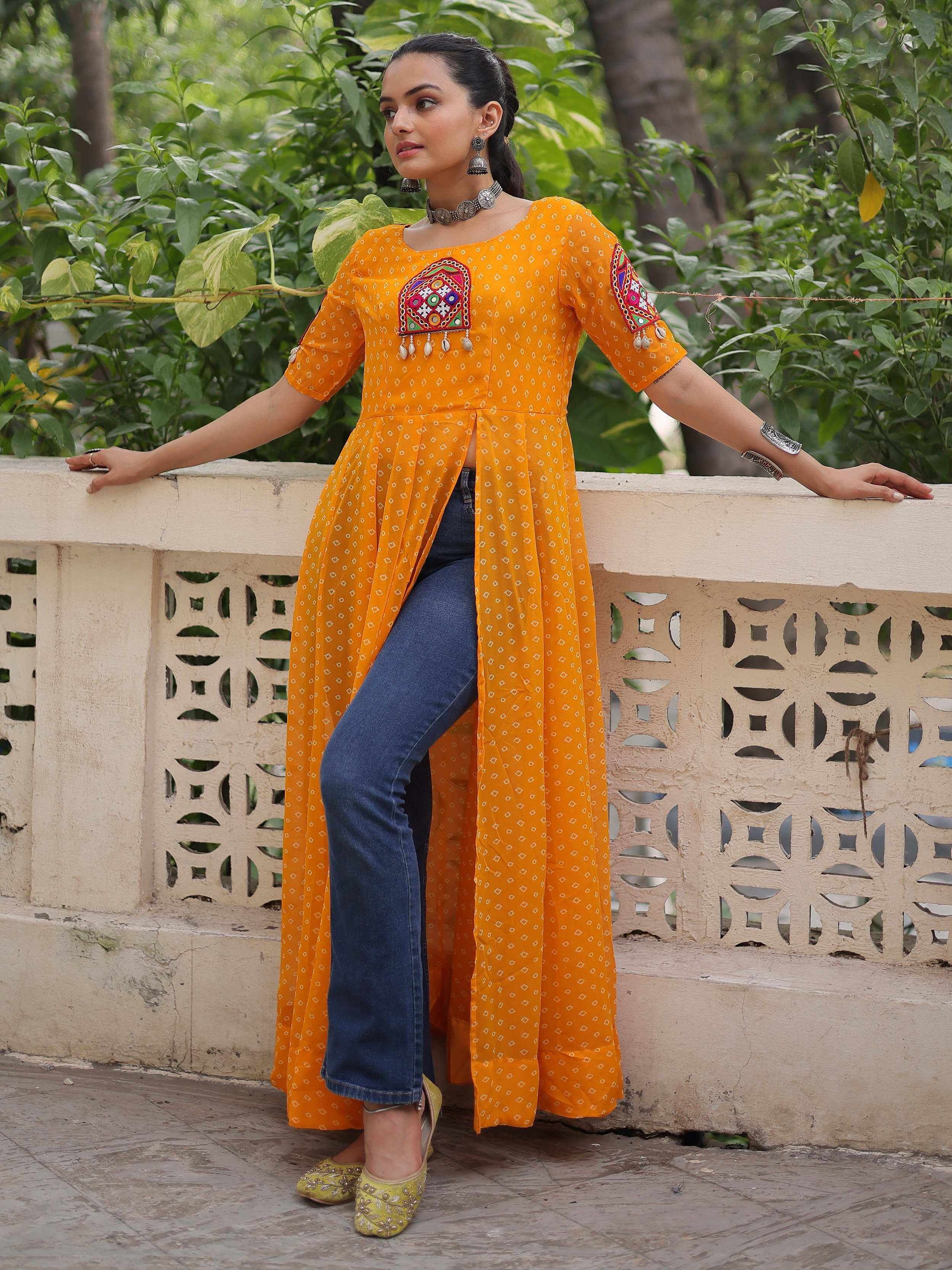 Orange embroidered kurta with mirror work, paired with jeans and juttis, styled for ethnic wear
