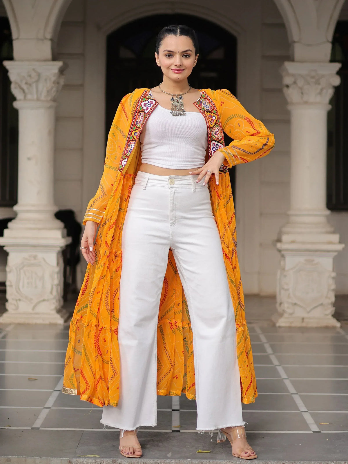 Vibrant yellow embroidered ethnic jacket with white crop top and wide-leg pants, perfect for Indian fashion trends