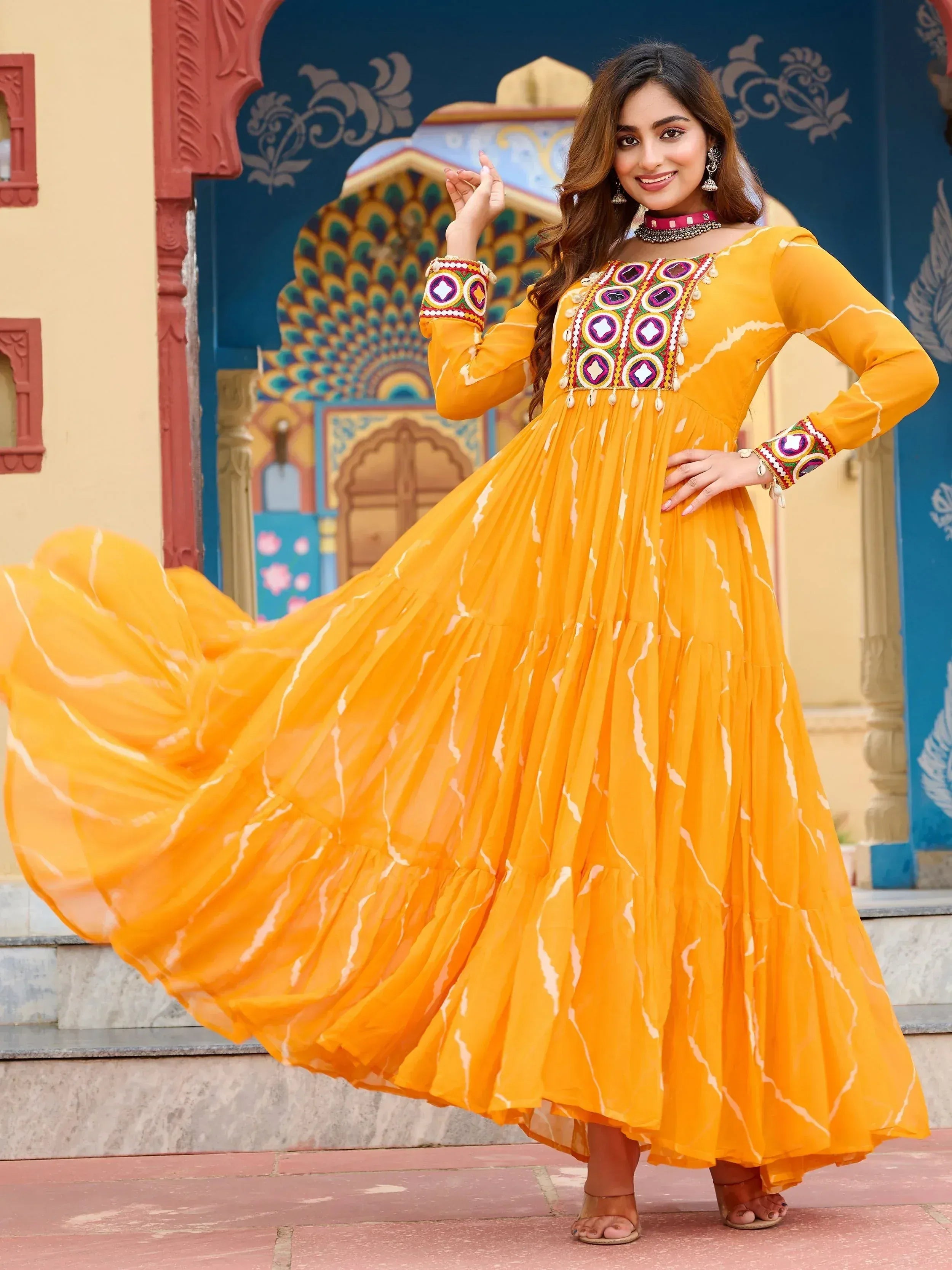 Vibrant yellow ethnic gown with mirror work, perfect for Indian celebrations and festive occasions.
