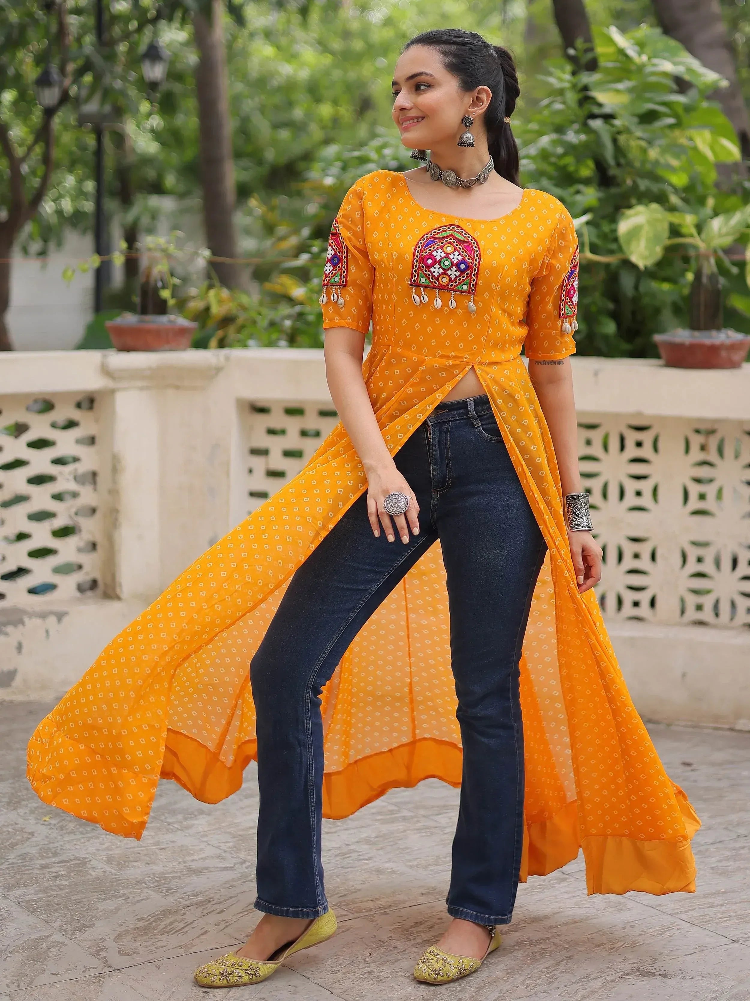 Yellow embroidered ethnic kurta with side slit paired with jeans, perfect for fusion wear