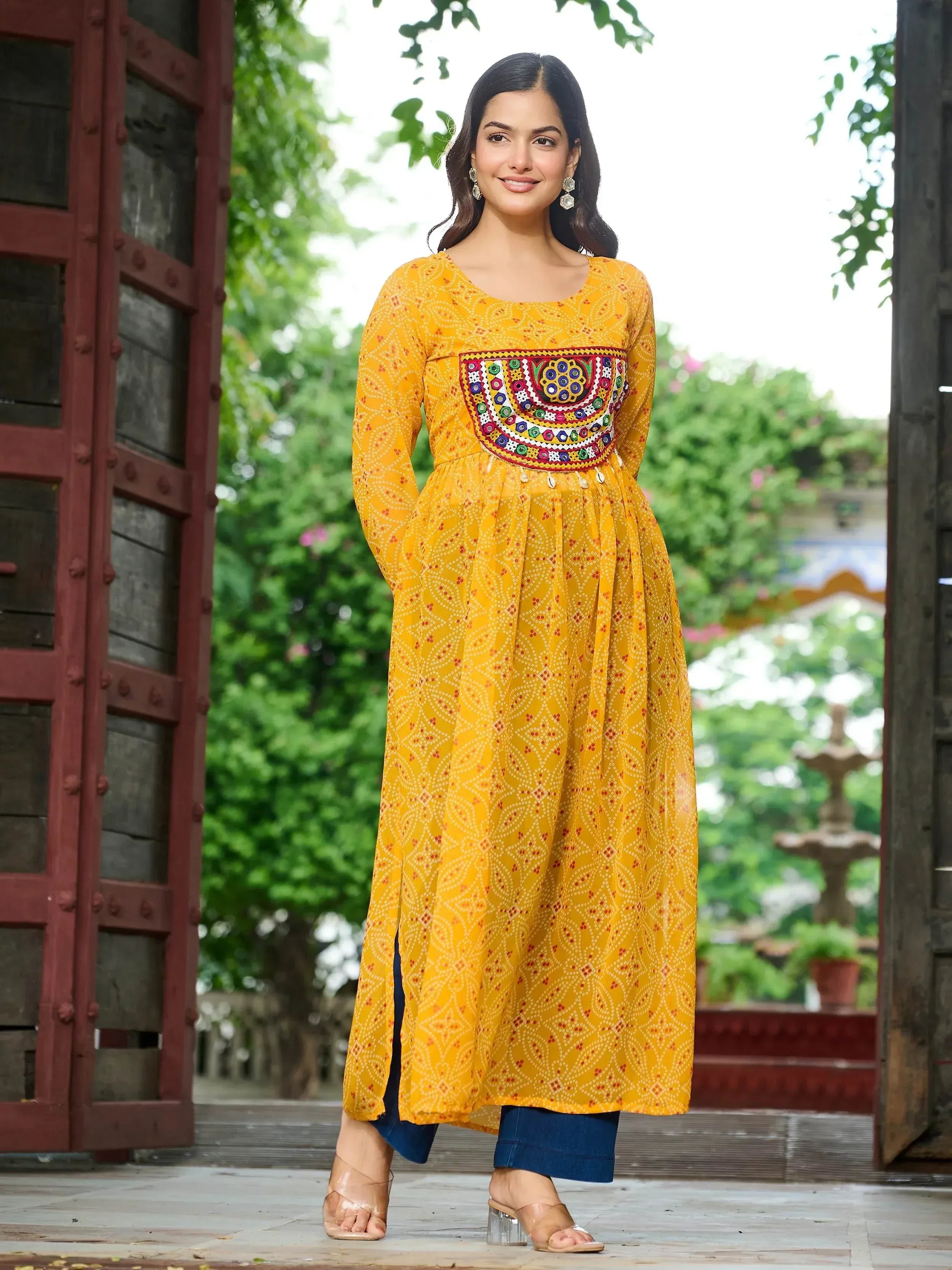 Yellow ethnic kurta with colorful embroidery, paired with blue jeans and heels, perfect for festive occasions.